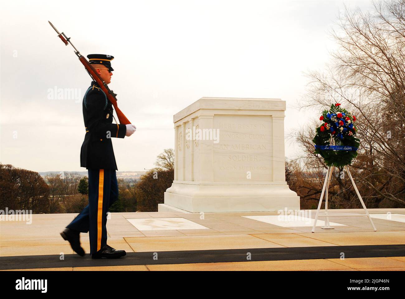 Eine Wache geht vor dem Grab des unbekannten Soldaten auf dem Nationalfriedhof von Arlington in der Nähe von Washington, DC, und ehrt die im Einsatz Getöteten Stockfoto