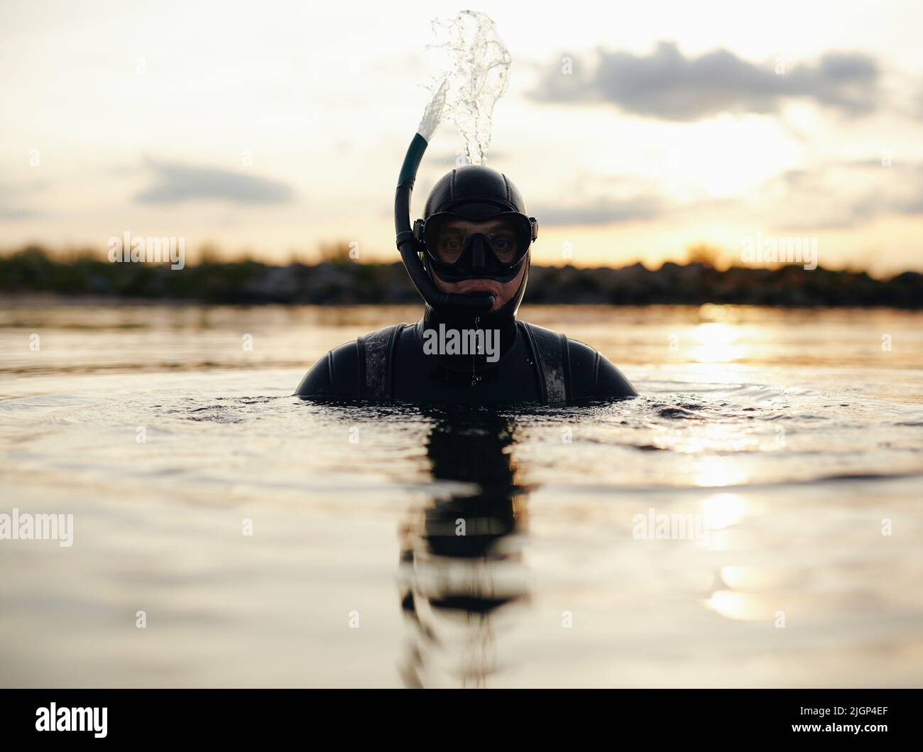 Abenteuerlicher junger Mann, der mit einer Schnorchelausrüstung im Meer schnorchelt. Männlicher Taucher, der mitten im Ozean schwimmend ist. Stockfoto