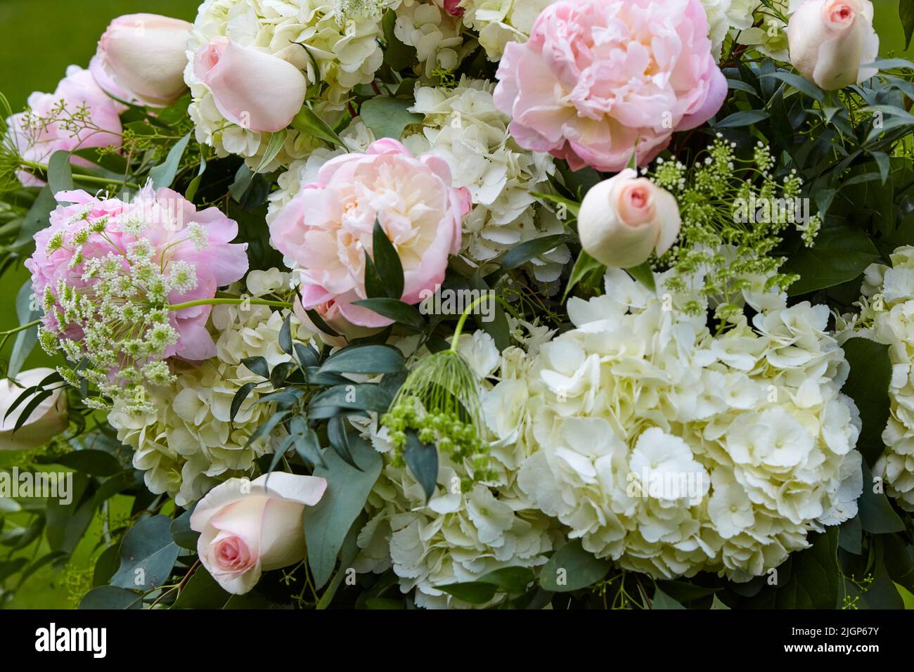 Blumenarrangement zur Hochzeit mit Pfingstrosen und Rosen. Stockfoto