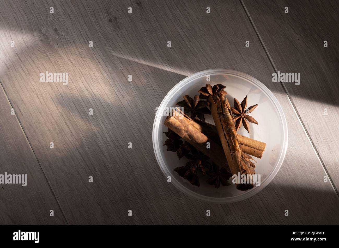Zimt und Sternanise in einer undurchsichtigen Schale auf einem hellen Holztisch arbeiten Hintergrund mit Kopierraum Stockfoto