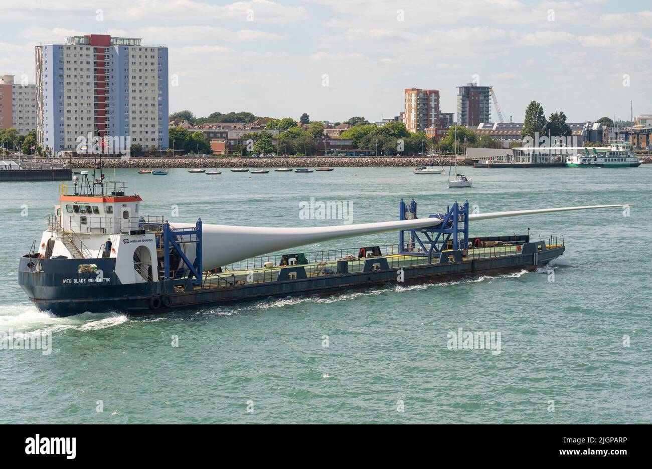 Portsmouth, Südengland, Großbritannien. 2022. Windturbinenblatt als Ladung auf Blade Runner zwei Schiffe unterwegs in Portsmouth Hafen. Hintergrund von Gosport, Stockfoto