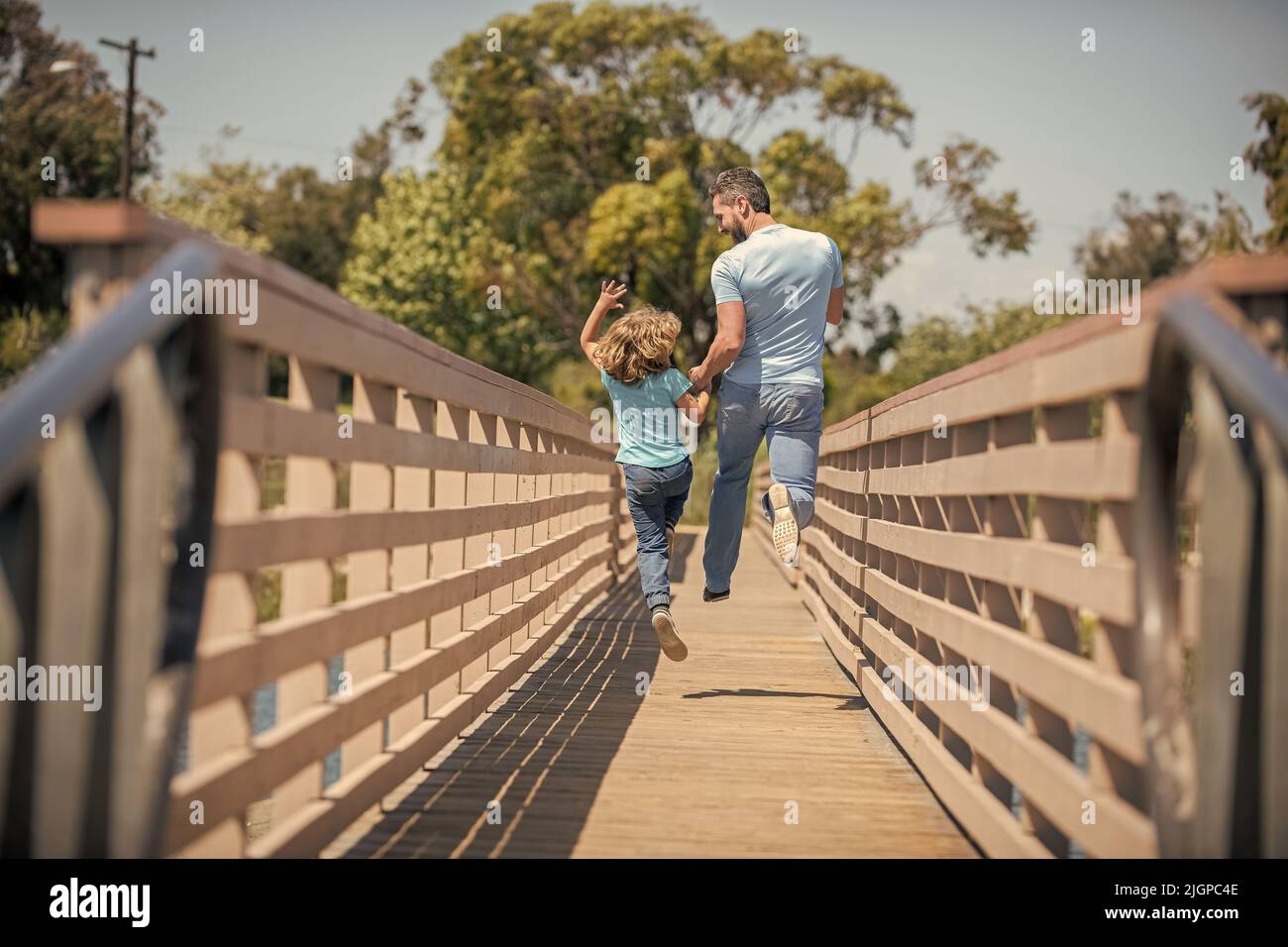 Glücklicher Vater, der Spaß hat, mit seinem Sohn draußen zu laufen, Rückansicht, Vaterschaft Stockfoto
