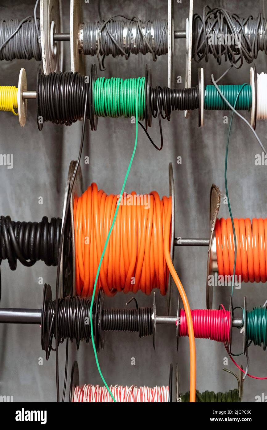 Spulen aus mehrfarbigen elektrischen Drähten in einem Baumarkt. Stockfoto