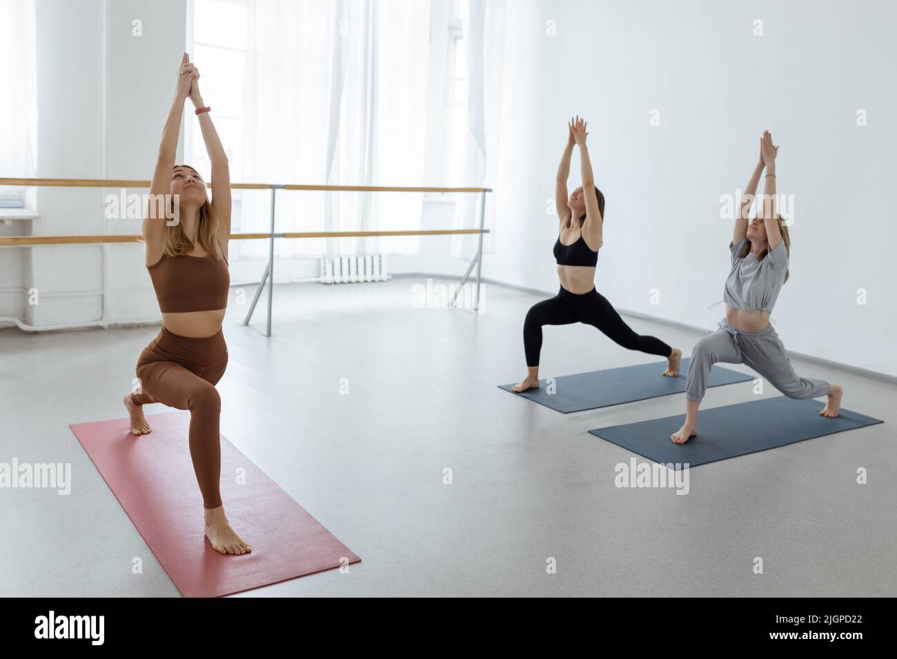 Gruppe von jungen Mädchen, die Yoga in Windmühle Pose, Entspannung und Meditation Konzept üben Stockfoto