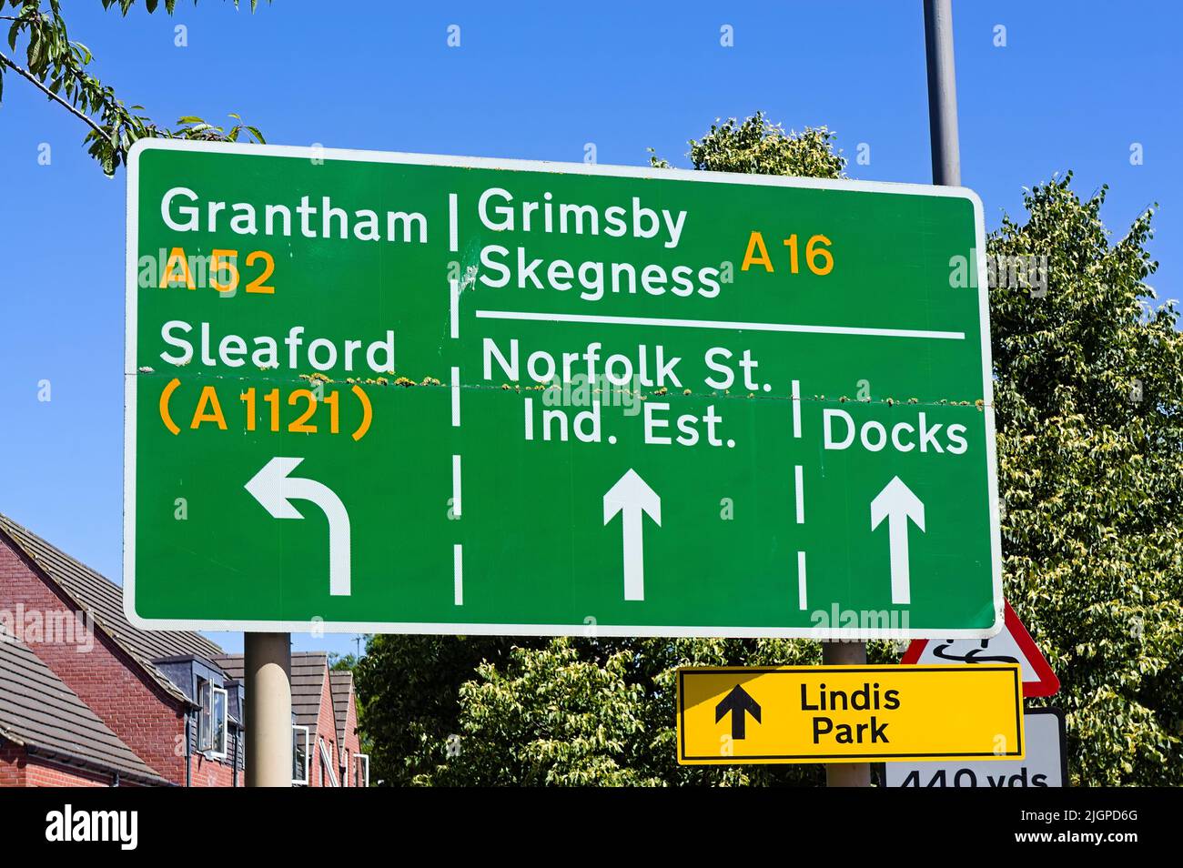 Ein grünes Straßenschild mit Wegbeschreibung nach Grantham, Sleaford, Grimsby und Skegness mit blauem Himmel und Gebäuden im Hintergrund in Boston Lincolnshire Stockfoto