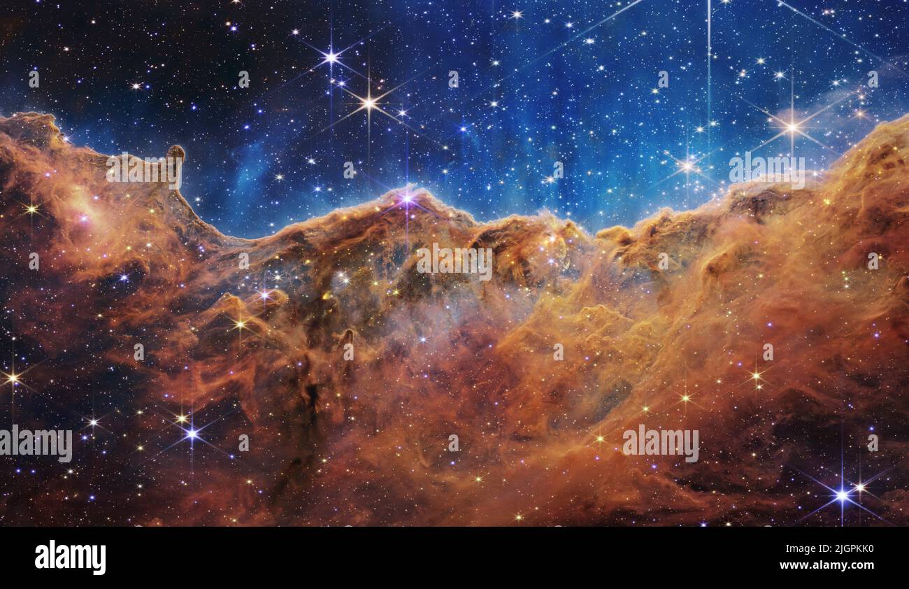 Die ersten Bilder des James Webb Weltraumteleskops – die höchstverfügbare Auflösung der Region Cosmic Cliffs des Carina Nebels, aufgenommen mit der Near-Infrared Camera (NIRCam). Dadurch werden zuvor verdeckte Bereiche der Sterngeburt sichtbar.die Region, die Cosmic Cliffs genannt wird, ist tatsächlich der Rand eines riesigen, gasförmigen Hohlraums, der etwa 7600 Lichtjahre entfernt ist. Das Gebiet wurde durch die intensive UV-Strahlung und die Sternwinde massiver, heißer, junger Sterne, die sich in der Mitte der Blase oberhalb des gezeigten Bereichs befinden, aus dem Nebel erodiert. 12. Juli 2022 Quelle: NASA, ESA, CSA und STScI / Alamy Live News via Digitaleye Stockfoto