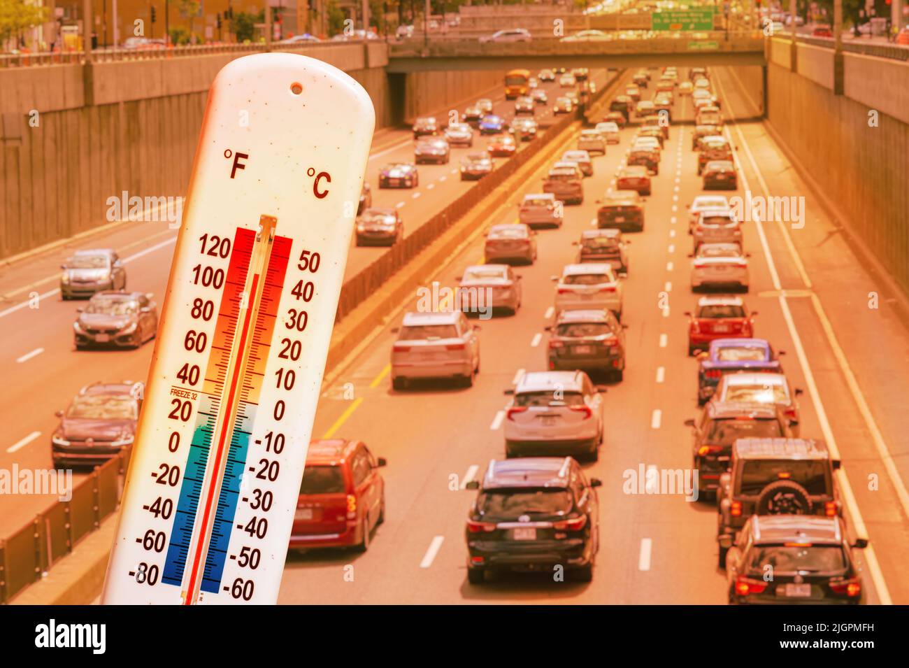 Thermometer vor dem Auto und Verkehr während der Hitzewelle in Montreal. Stockfoto