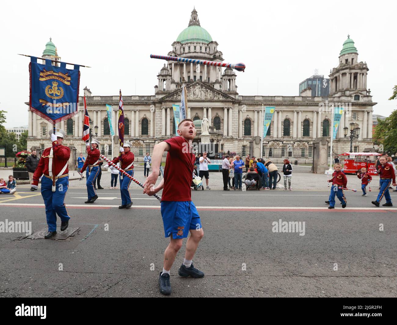 Ein Schlagzeugmajor von Freiwilligen aus Monkstown Young Bürgers wirft während der Rückkehr der Parade vom 12. Juli in Belfast einen Schlagstock in die Luft vor dem Rathaus von Belfast, Im Rahmen der traditionellen zwölften gedenkfeiern zum Jahrestag des Sieges des protestantianischen Königs Wilhelm gegen den katholischen König James in der Schlacht an den Boyne im Jahr 1690. Bilddatum: Dienstag, 12. Juli 2022. Stockfoto