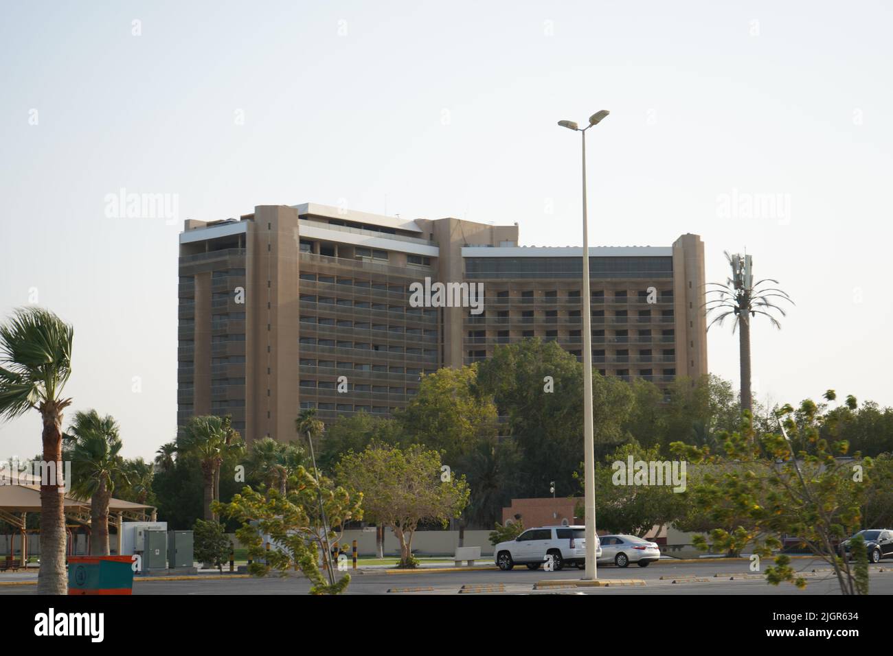 Hohes Gebäude mit blauem Himmel, einigen Palmen und windigem Wetter. Saudi-Arabien, Khobar, 10, Juni 2022. Stockfoto