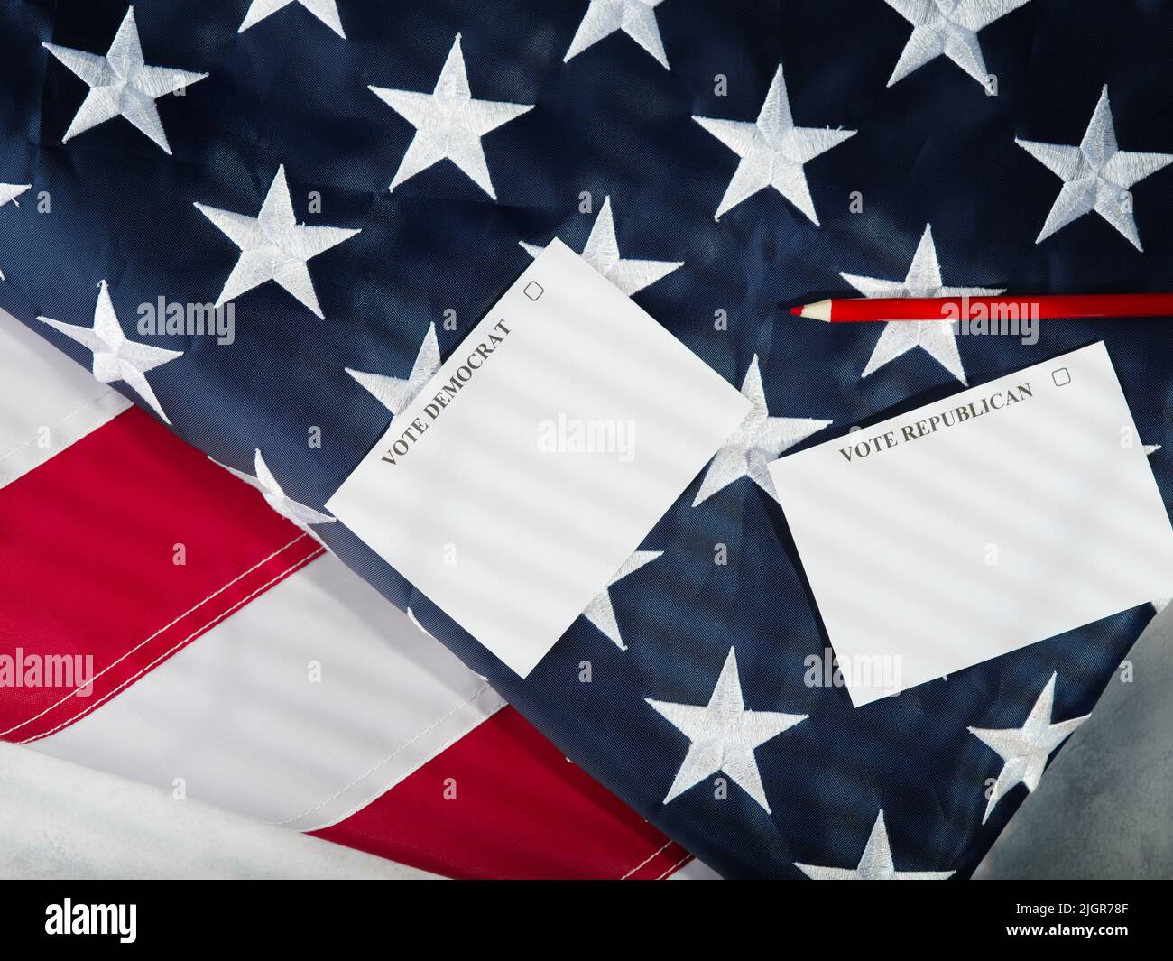 Parlamentswahlen. Demokraten und Republikaner. Zwei Blatt Papier und ein roter Bleistift auf dem Hintergrund der amerikanischen Flagge. Low-Angle-Ansicht. Befreit Stockfoto