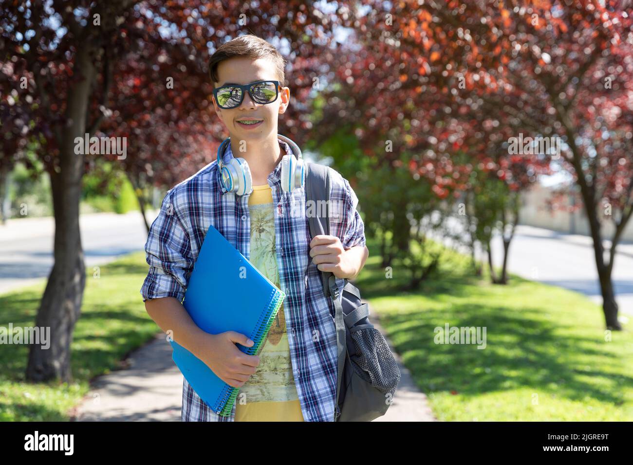 Glücklicher Teenager kaukasischer Student mit Rucksack, der zur Highschool geht. Außenportrait. Platz für Text. Stockfoto