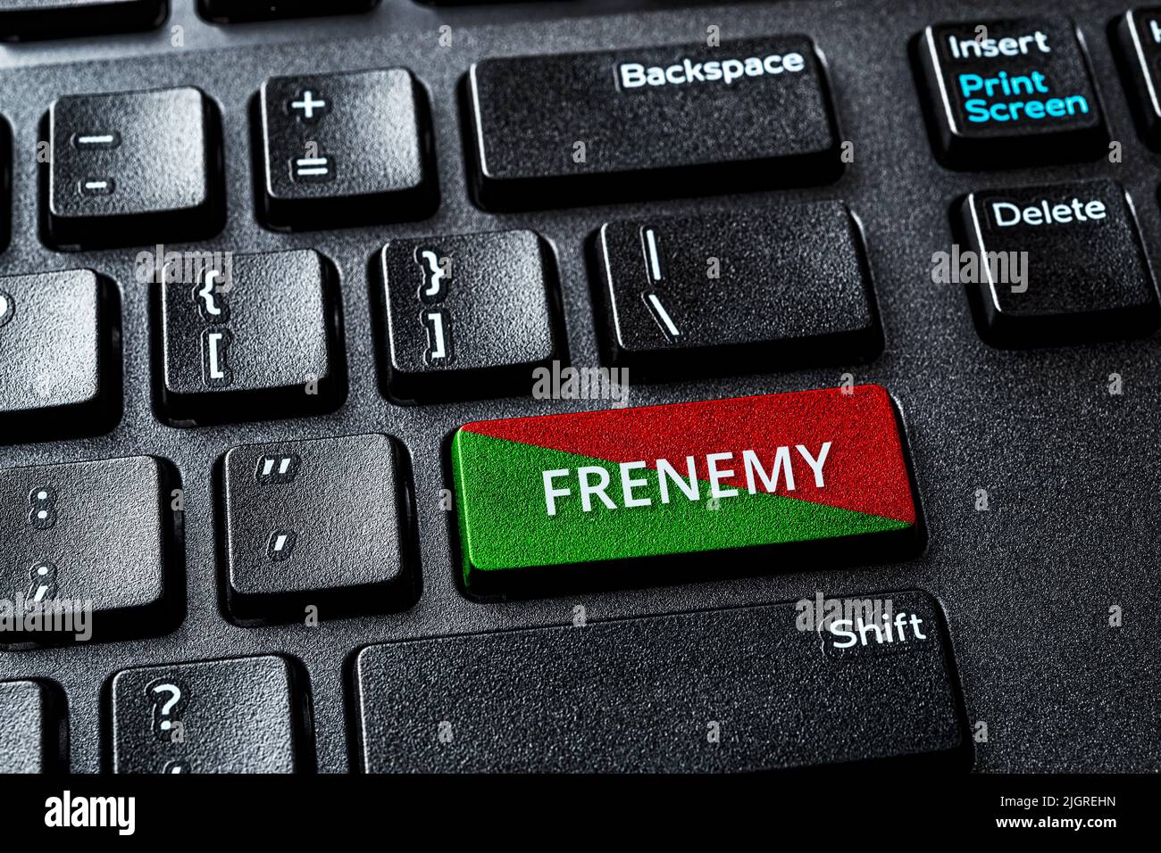 Frenemy Wort auf der grünen roten ENTER-Taste einer Computertastatur. Laptop ENTER-Schlüssel mit Warnmeldung. Seien Sie ein Feind, während Sie vorgeben, ein Freund zu sein. Stockfoto
