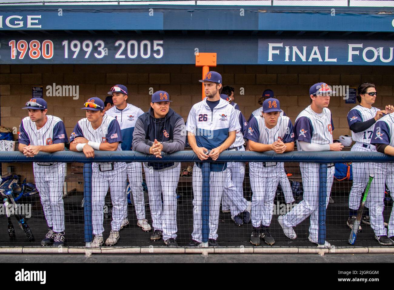 Mitglieder des Baseballteams des Orange Coast College unterhalten sich vor einem Spiel in Costa Mesa, CA, im Dugout. Notieren Sie die Daten der Gewinnsaison. Stockfoto