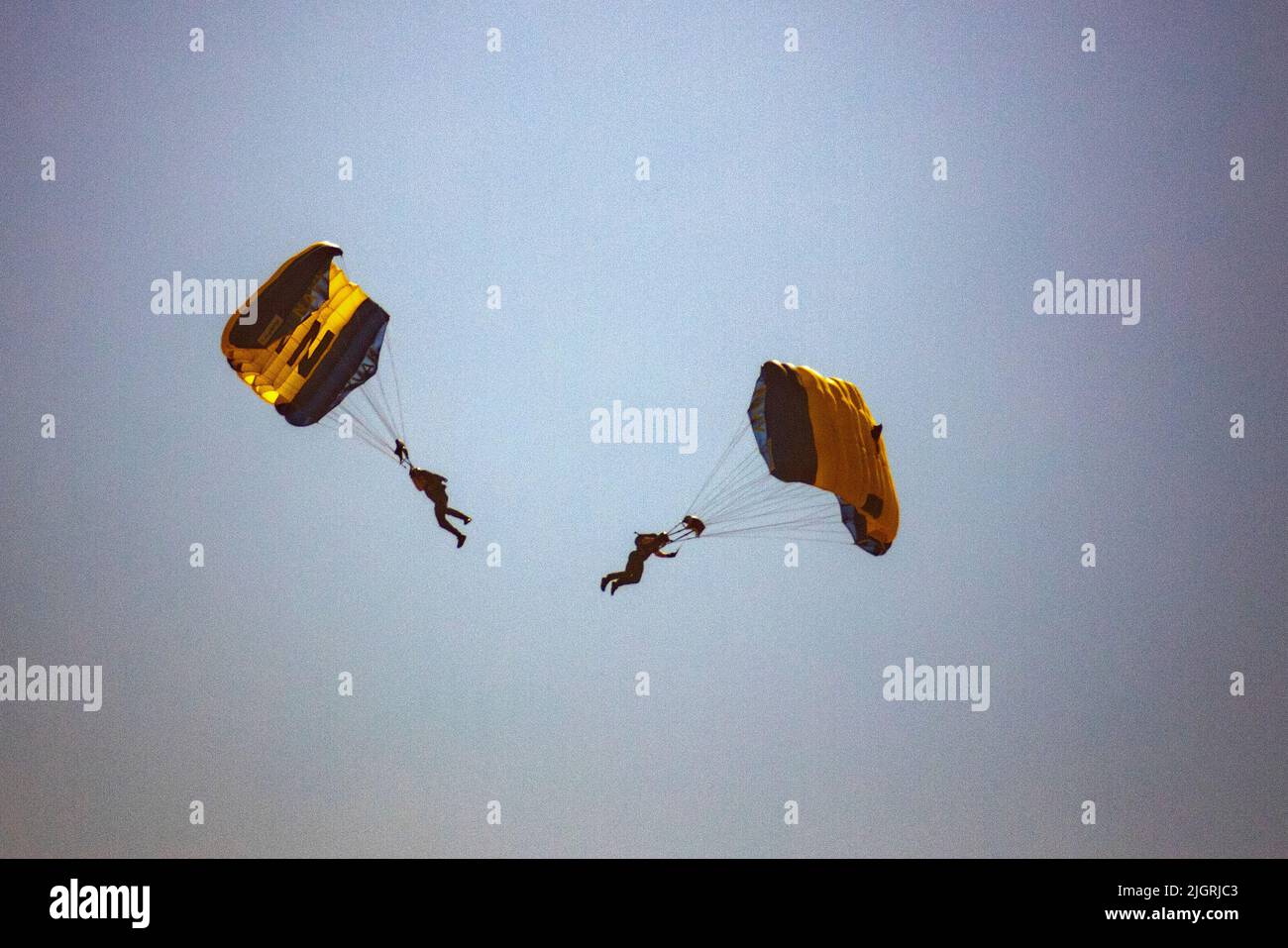 Zwei Mitglieder der US Navy Leap Frogs Flag Jump Parasail über Huntington Beach, CA, zur Feier des 4.. Juli. Stockfoto