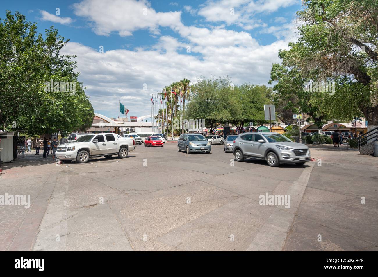 Viel Verkehr und Straßenszene mit Menschen in Nogales. Autos kommen aus den USA nach Mexiko. Stockfoto