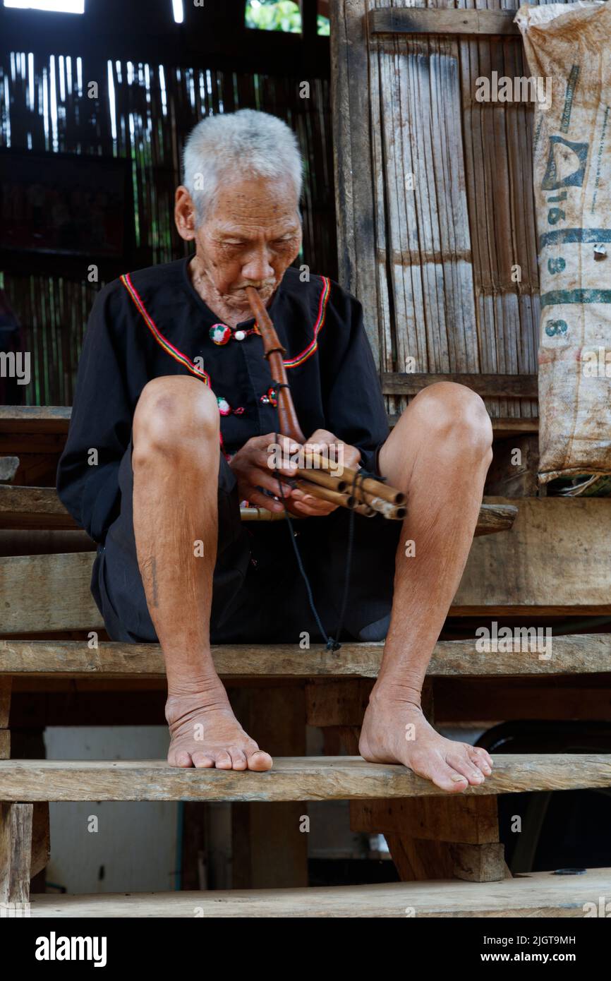 Ein DORFBEWOHNER AUS LIHU spielt eine einheimische Flöte in einem Dorf entlang des MAE KOK Flusses von Thaton bis Chiang Rai - THAILAND Stockfoto