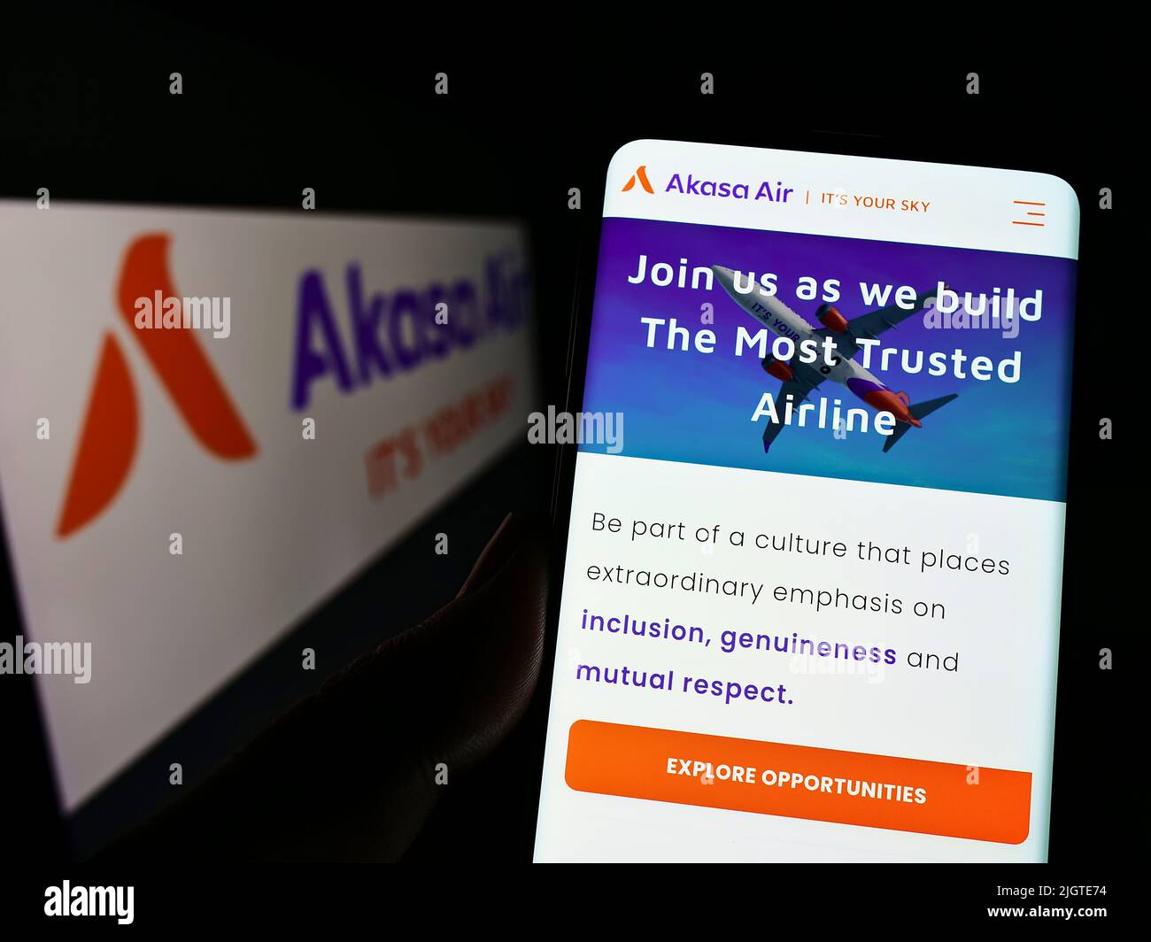 Person mit Mobiltelefon und Webseite der Fluggesellschaft SNV Aviation Private Limited (Akasa Air) auf dem Bildschirm mit Logo. Konzentrieren Sie sich auf die Mitte des Telefondisplays. Stockfoto