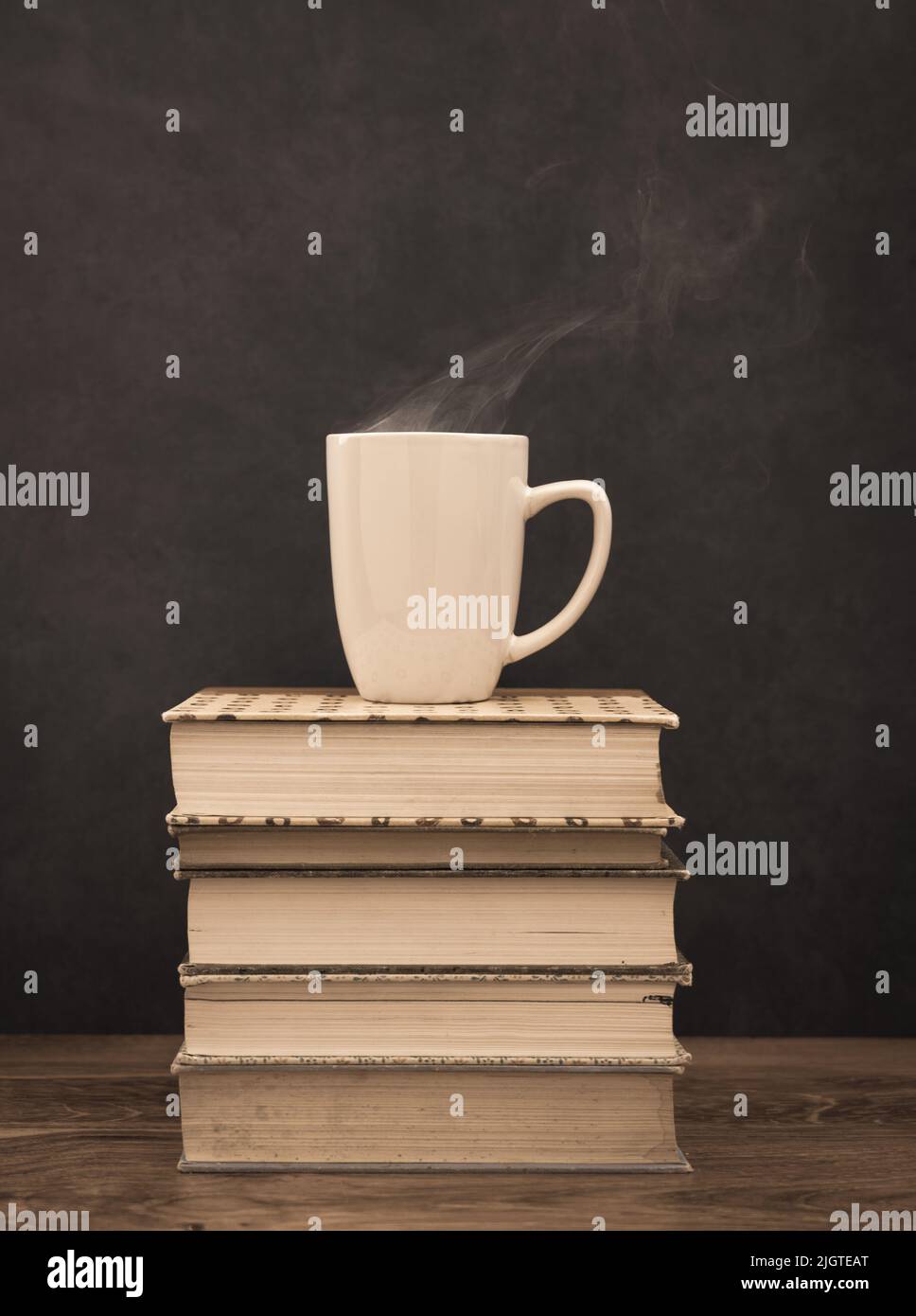 Tasse heißen Kaffee auf einem Stapel alter Bücher Stockfoto