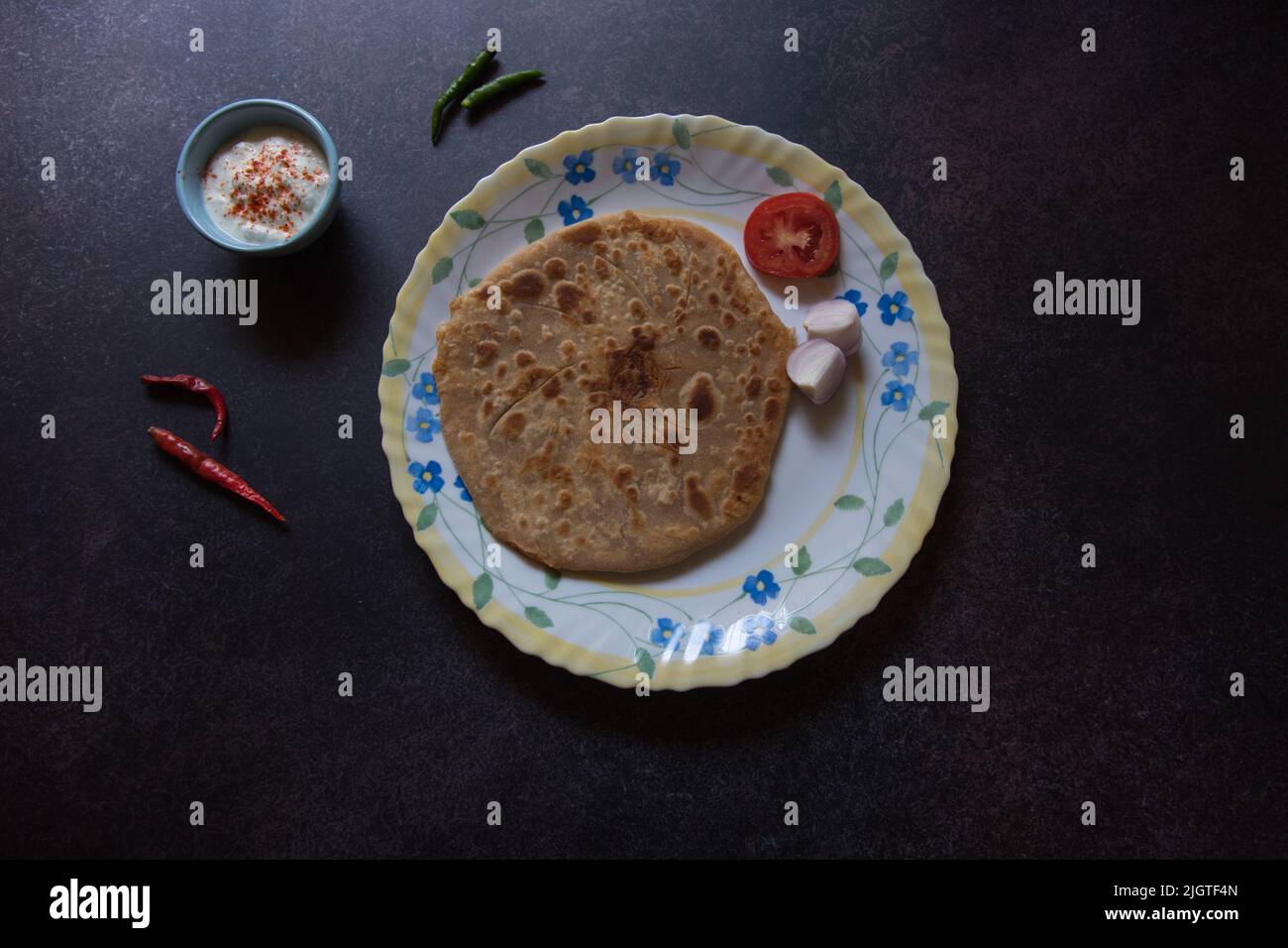 Es wird ein indisches Frühstück mit Aloo Paratha oder gefülltem Fladenbrot mit Kartoffeln serviert. Stockfoto