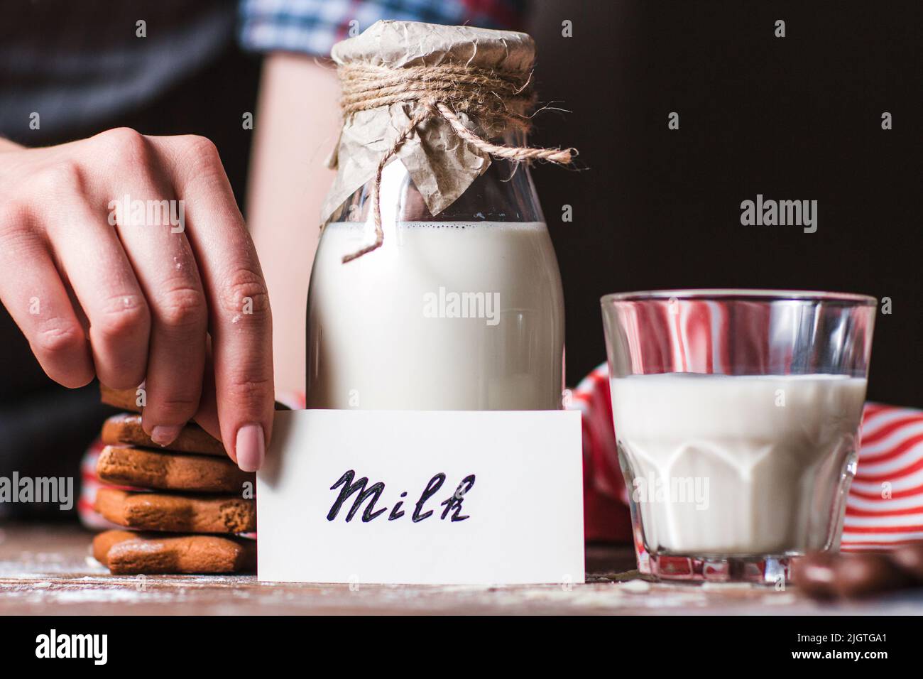 Frau mit Karte in der Nähe einer Flasche Milch Stockfoto