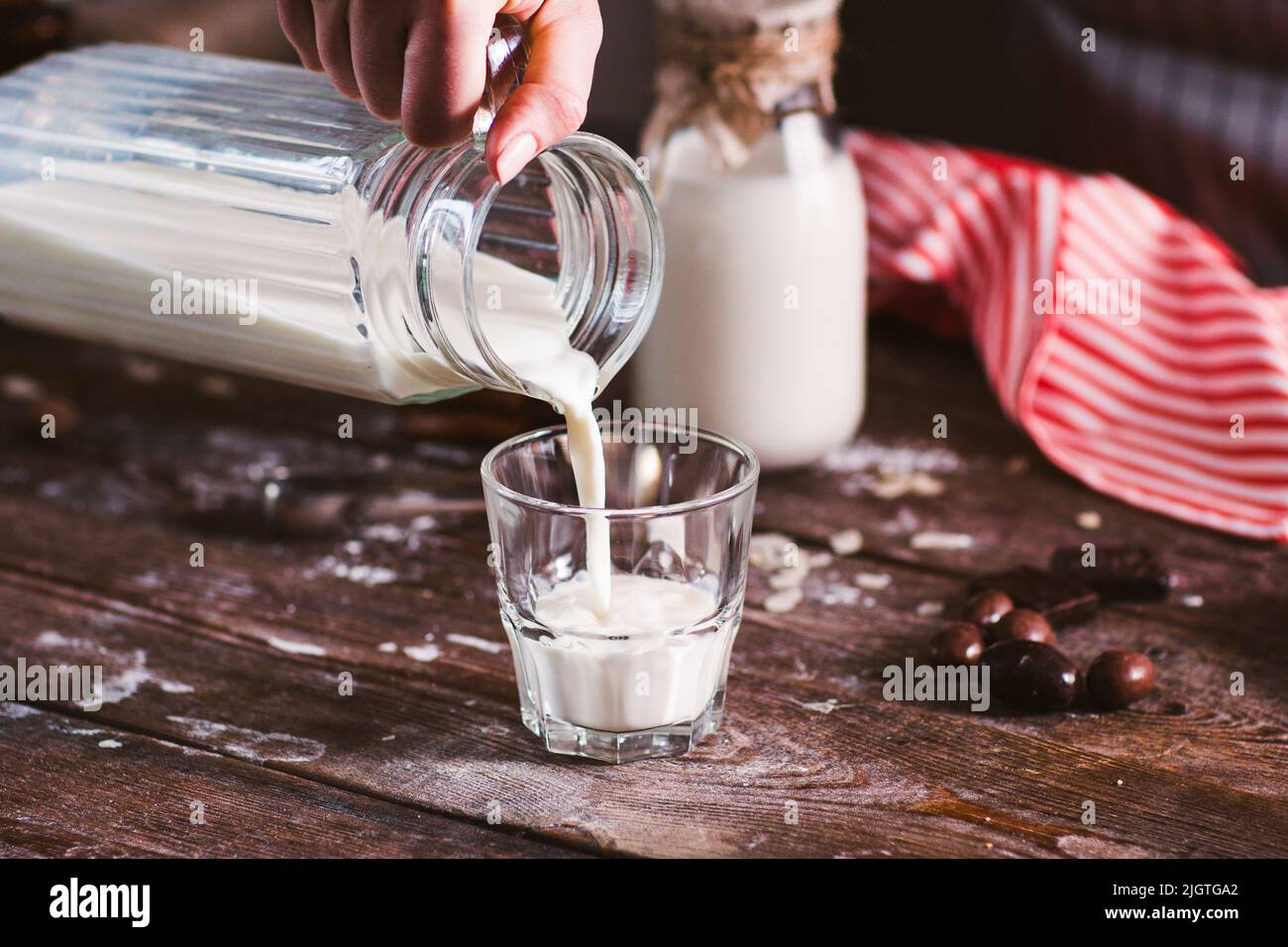 Gießen Sie neue Milch aus der Nähe in das Glas Stockfoto