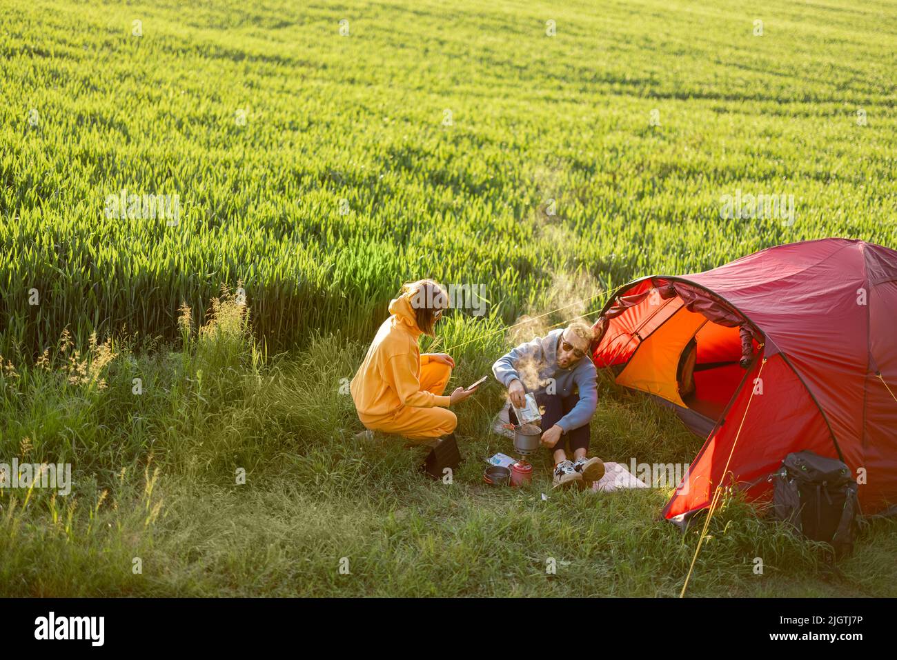 Paar auf dem Campingplatz mit Zelt auf einem grünen Feld Stockfoto