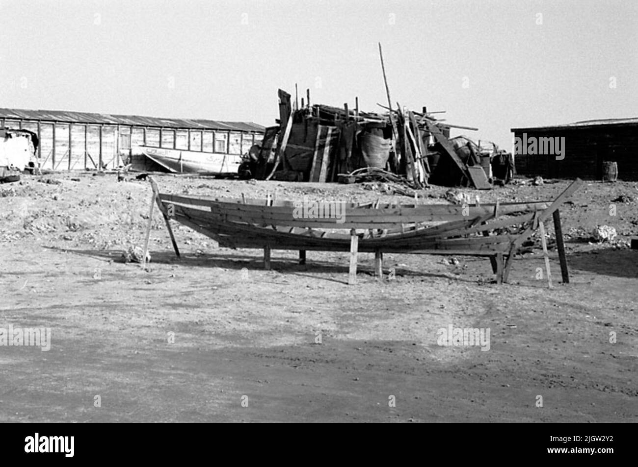African trip, Port Sudden Acquisition: Bücher und Archivmaterial.36 Bilder in Serien. Das Foto wurde ungefähr 1961-08-22 aufgenommen. Ein Boot befindet sich an einem Strand zur Renovierung. Es fehlt an Tischplanken. Im Hintergrund sind einige magazinartige Gebäude zu sehen. Stockfoto