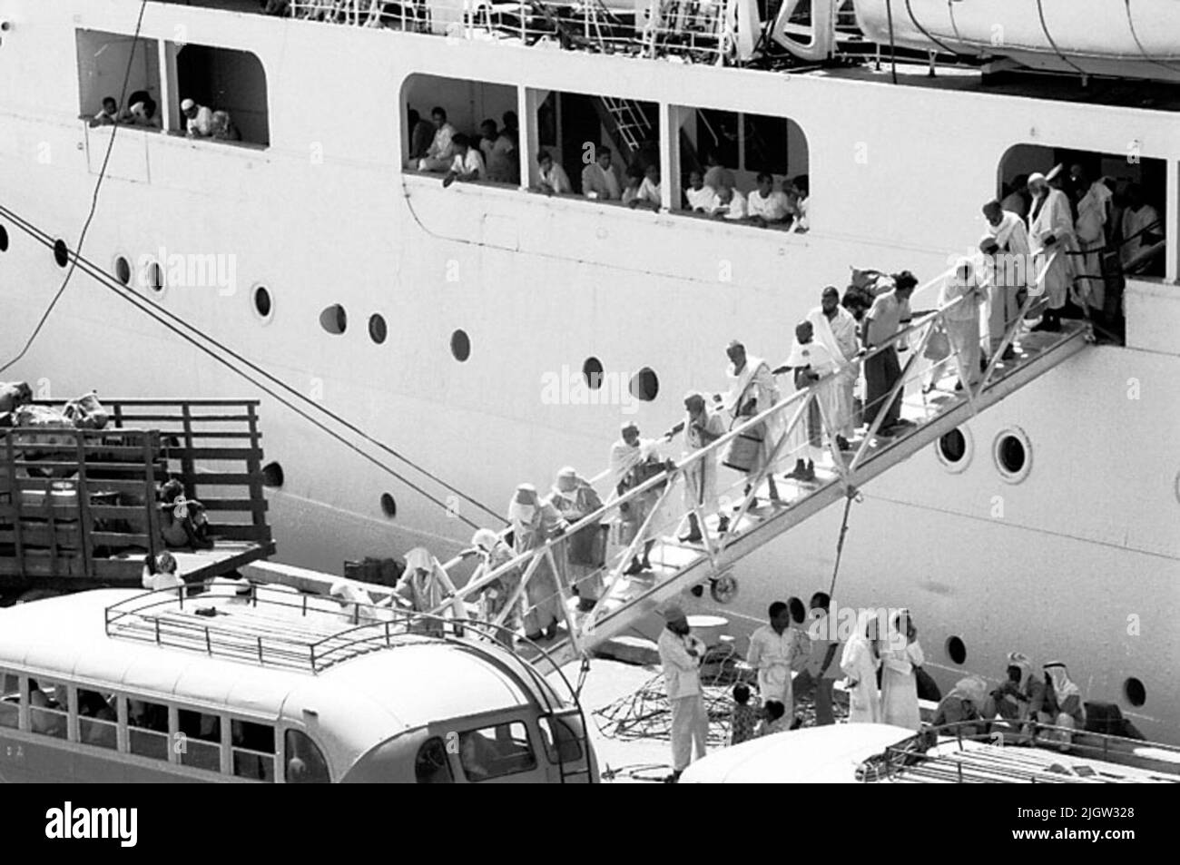 African trip, Jeddahsom -term acquisition: Bücher und Archivmaterial.35 Bilder in Serien. Das Foto wurde ungefähr 1961-08-15 aufgenommen. Ein Passagierschiff aus Pakistan. Ein paar Männer und Frauen gehen zum Kai hinunter. Am Kai fahren zwei Busse. Stockfoto