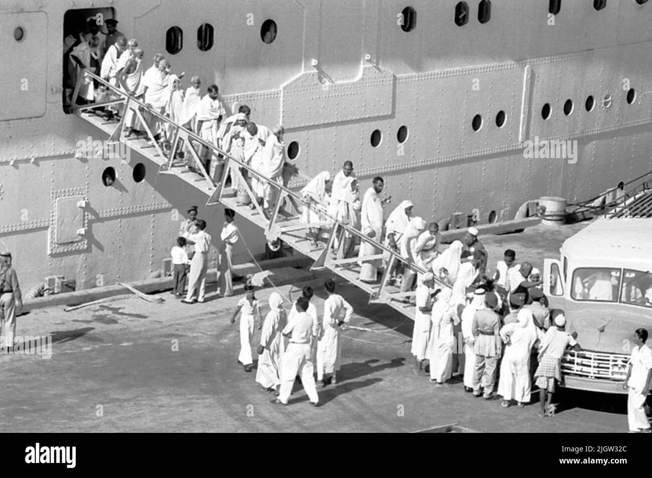Ein Passagierschiff aus Pakistan. Männer und Frauen gehen zum Kai hinunter. Am Kai steht ein Bus.35 Bilder in Serie. Stefan Zylberstein kommentierte das Bild über Västarvet Search in den Sammlungen 2013-01-13: 'Jeddah ist Mekkas Hafenstadt. Dies ist sicherlich ein Passagierboot mit muslimischen Pilgern nach Mekka, und es kann gesagt werden, vielleicht und vielleicht. Hundert Busse entlang des Kais, aber wie wir nicht sehen. „Afrikanische Reise, Jeddah Stockfoto