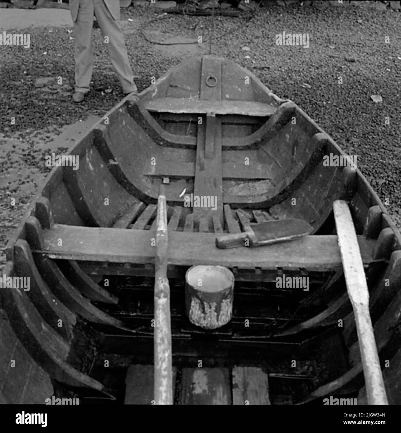 2. Die Niederlande, Frankreich. Photo Journal ist erhältlich bei B.M.A. + Fotoalben. Erwerb: Bücher und Archivmaterial. Fotos aufgenommen zwischen 1959-10-12. Und 1959-10-16,12 Bilder in Serie. Laut Notizen: Niederlande, Dortse Kil/Waal 12/10-59. Flachbodenboot, älteres Holzboot. Außen und innen. Im Heck zur Befestigung des Außenbordmotors. Ein Boot befindet sich an einem Strand. Im Boot befinden sich zwei Ruder und eine Insel aus Holz. Auf dem Boden steht ein Tellereimer mit Deckel. Vor dem Boot steht ein Mann. Stockfoto