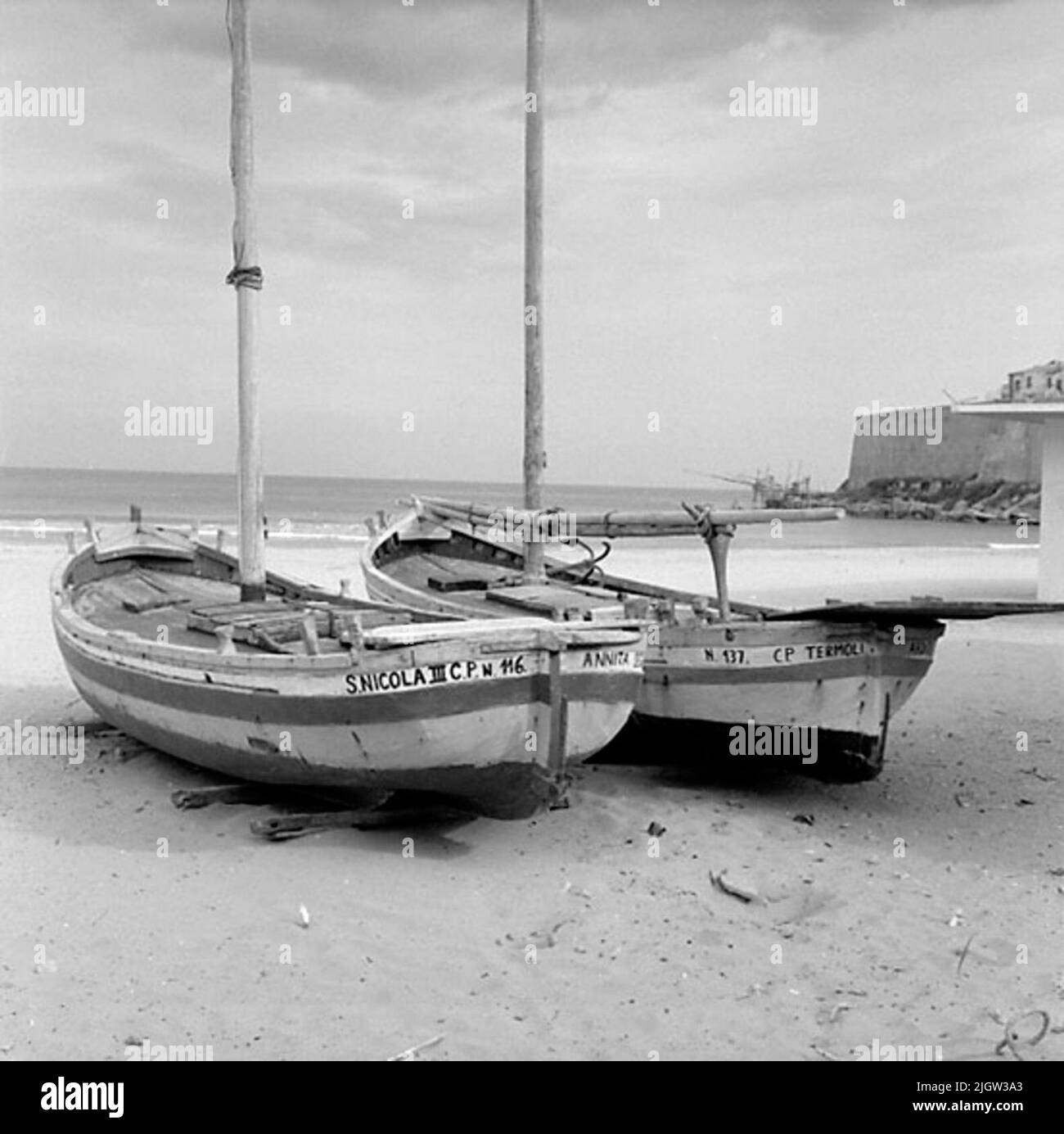 14. Schweden, Italien. Fotojournal ist bei B.M.A. erhältlich + Fotoalben. Erwerb: Bücher und Archivmaterial. Fotos aufgenommen 1959-10-28,12 Bilder in Serie. Nach Angaben: Italien. Adriaküste, Thermoli, 28/10 -59. Überdachte und unbedeckte Fischerboote mit lateinischen Rigs, die am Strand in Betrieb genommen wurden. Zwei Fischerboote befinden sich an einem Sandstrand. Draußen ist ein offenes Meer. Rechts ist eine Mauer am Wasser. Stockfoto