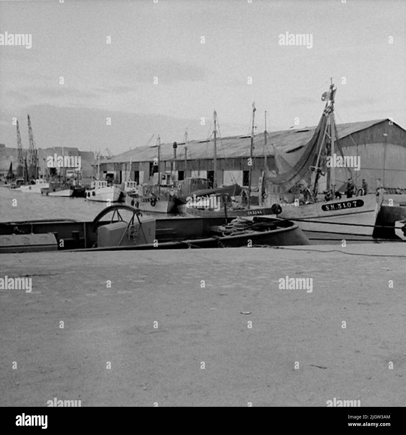 8. Frankreich. Fotojournal ist bei B.M.A. erhältlich + Fotoalben. Erwerb: Bücher und Archivmaterial. Fotos aufgenommen zwischen 1959-10-16 und 1959-10-1712 Bilder in Serie. Nach Angaben: Frankreich. Atlantikküste, St. Nazaire, 17/10 -59. Motortrawler im Hafen. Mehrere Boote befinden sich in einem Hafen. Am Kai gibt es ein paar Zeitschriften. Stockfoto