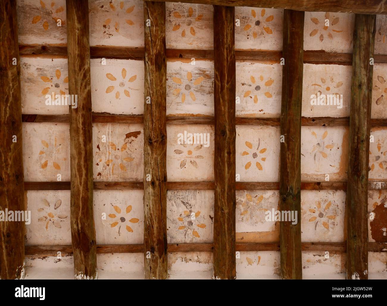 Alte Decke aus Holz mit Zeichnungen von Blumen in Gelb Stockfoto