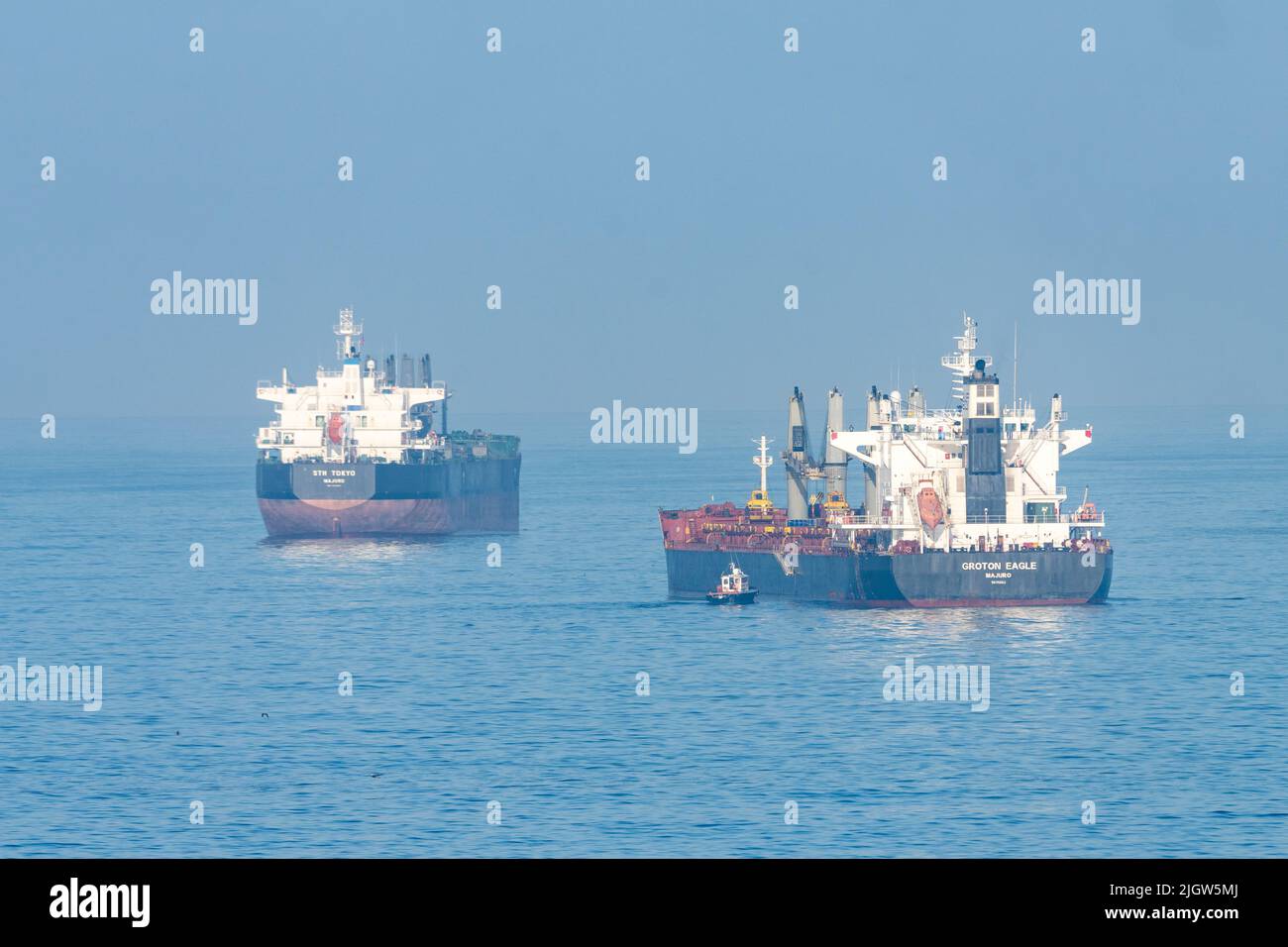 Ein Lotsenboot nähert sich dem Groton Eagle, einem Massengutfrachter vor Anker im Hafen von Antofagasta, Chile. Stockfoto