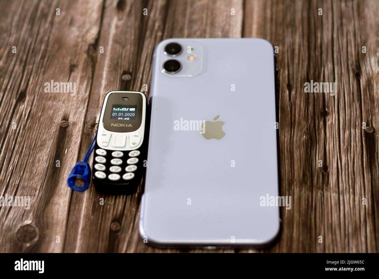 Kairo, Ägypten, Juni 11 2022: Apple iPhone 11 mit 6,1inch Liquid Retina HD High Definition Display und einem winzigen kleinen alten Nokia Mini-Handy mit einem ke Stockfoto
