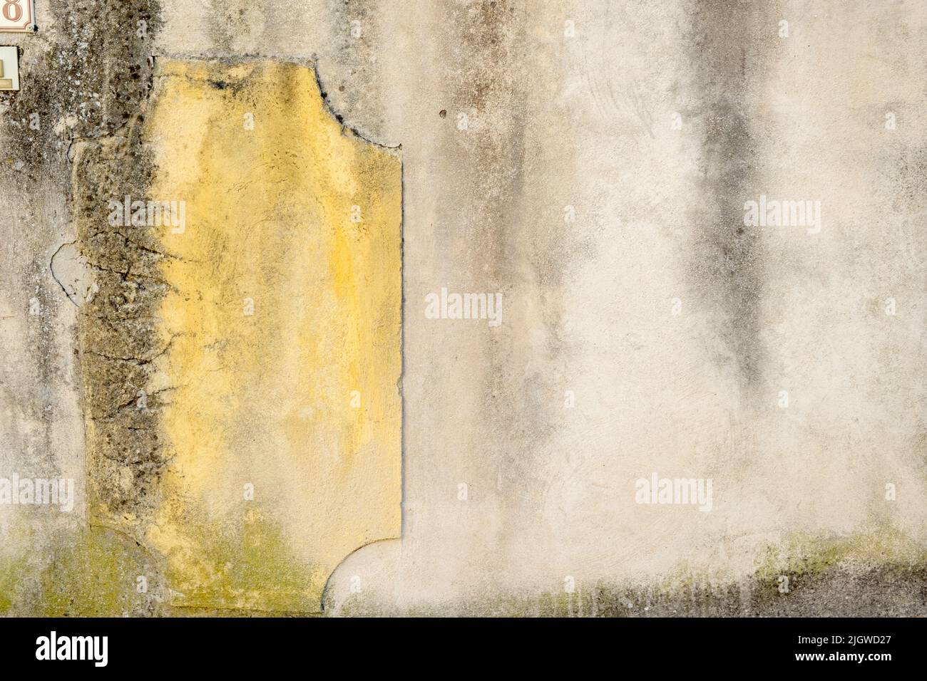 Nahaufnahme einer alten Stadtmauer mit abblätterndem und abgebrochenem Putz in Villes-sur-Auzon, Frankreich. Hintergrund-Kopierbereich. Stockfoto