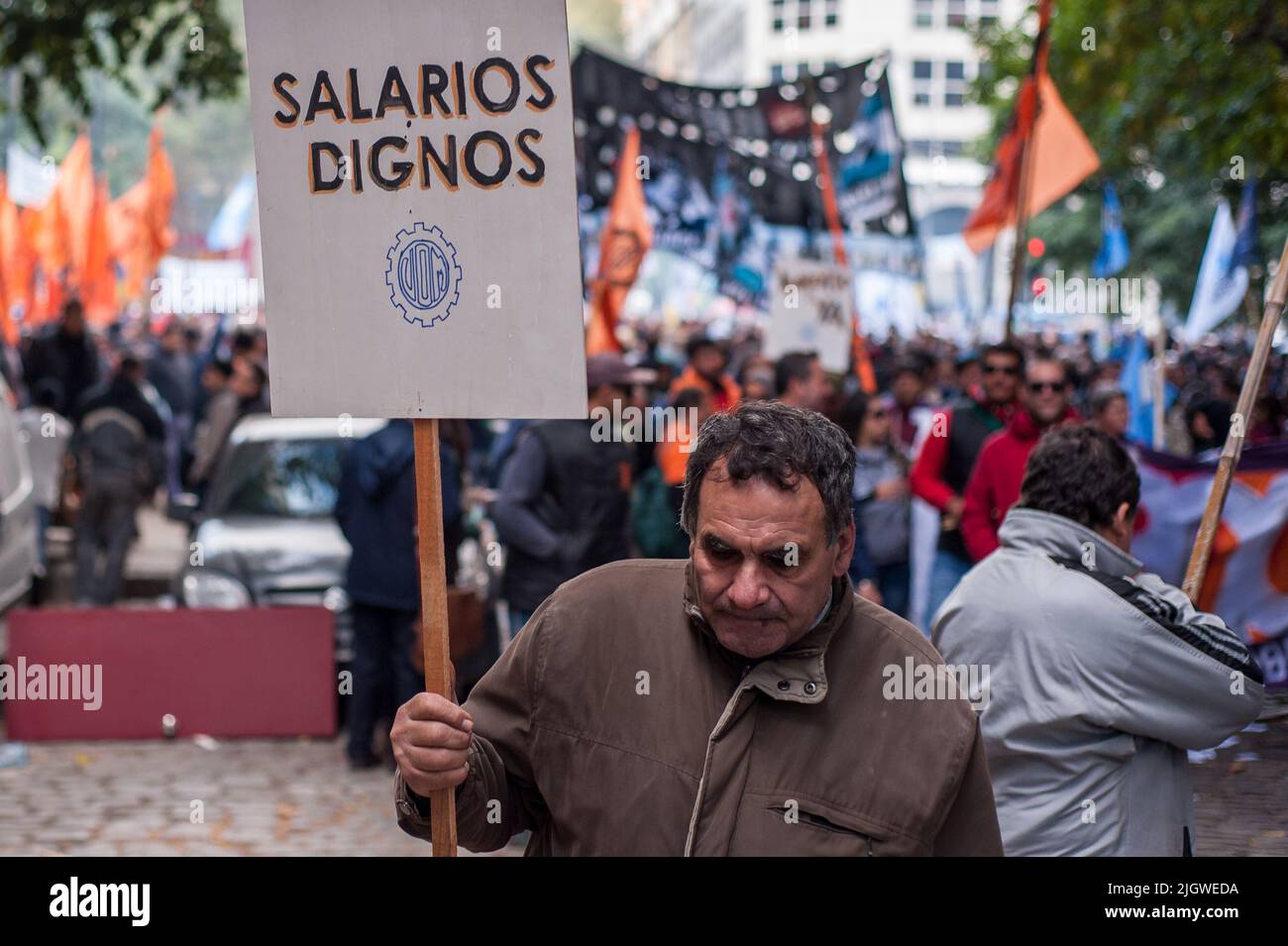 Ein Mann mit einem Plakat, der während einer Kundgebung zum Workers Day in Buenos Aires, Argentinien, anständige Gehälter fordert Stockfoto