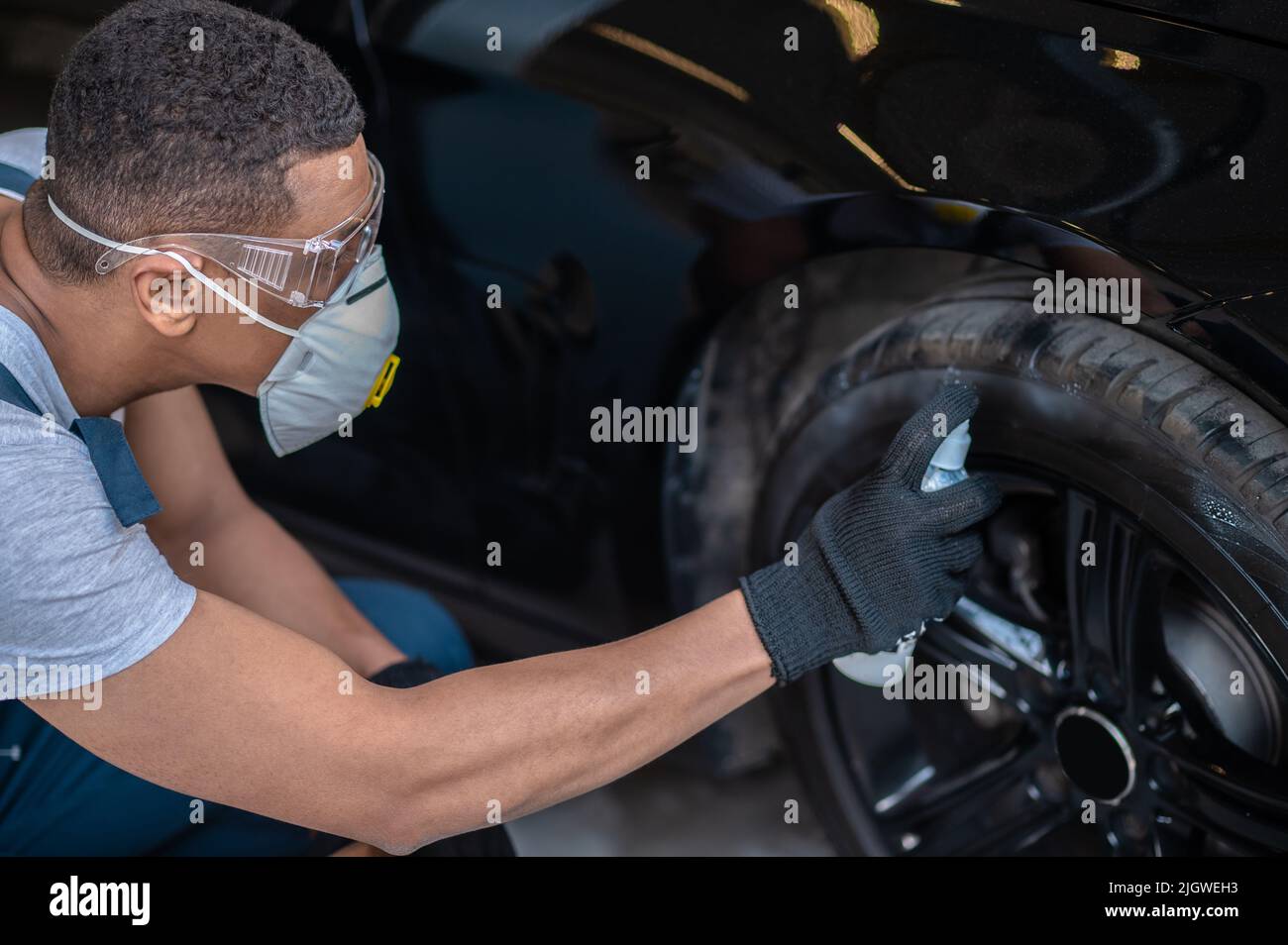 Automechaniker, der den Gummireifen poliert Stockfoto