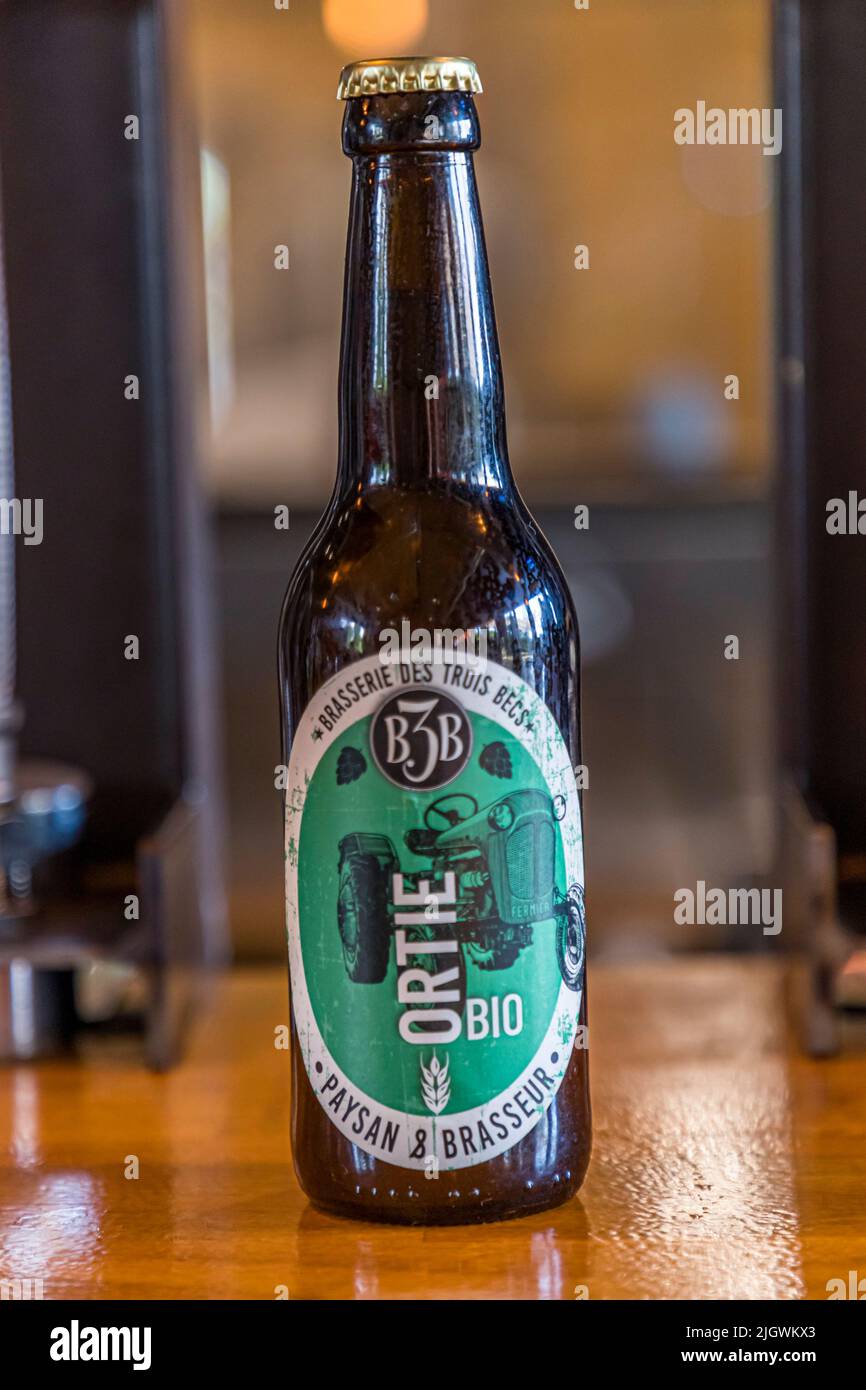 Eine Flasche „Ortie Bio“-Bier mit dem neuen Traktor-Etikett steht in der Brasserie des Trois Becs in Gigors-et-Lozeron, Drôme, Frankreich. Für dieses Bier ersetzt die Brauerei die Hälfte des üblichen Hopfengehalts durch Nesseln. Der Agrarwissenschaftler Emmanuel Feraa gründete die Bio-Brauerei 2015. Sie baut einen Großteil ihres eigenen Hopfens und Gerstes vor Ort an. Stockfoto