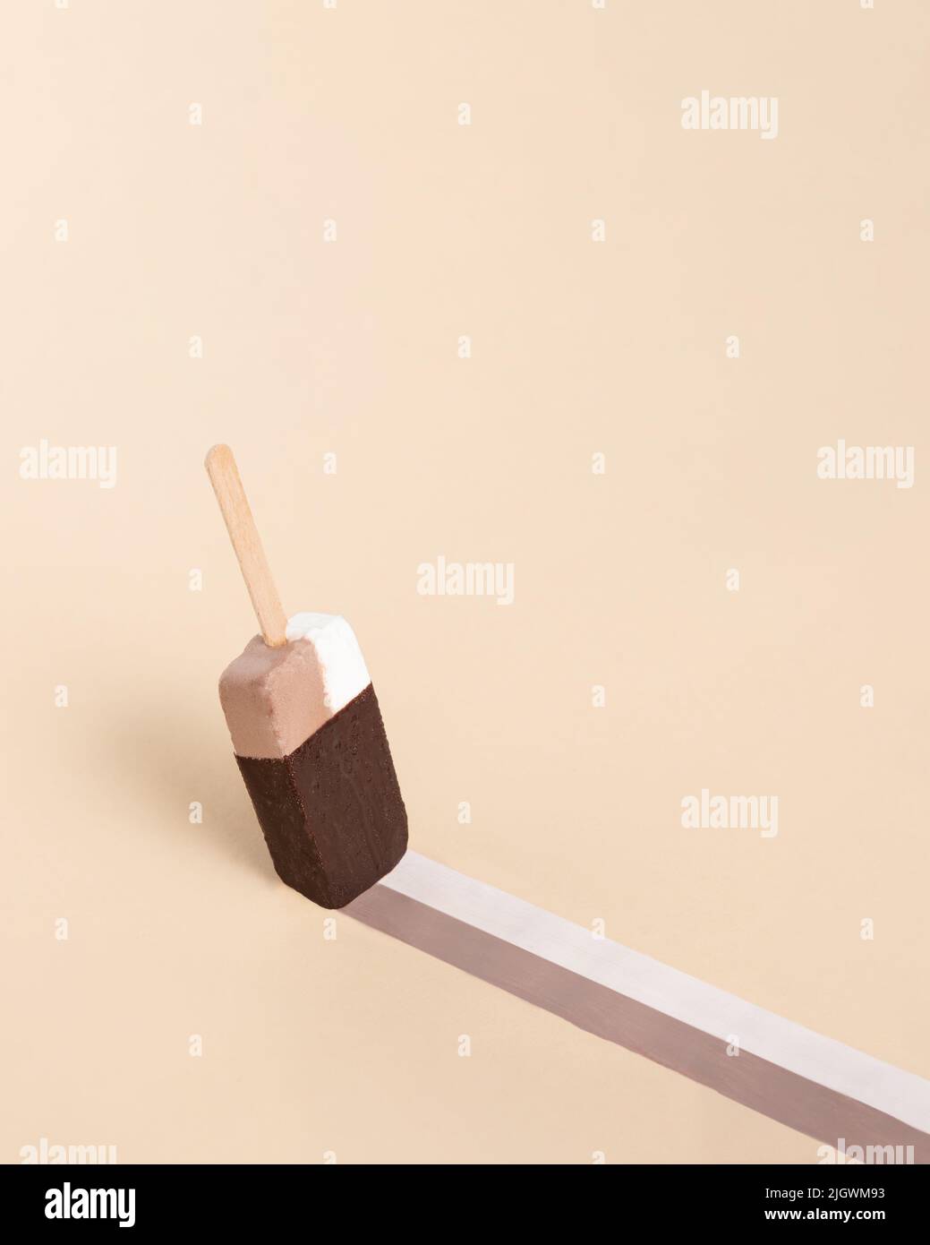Eiscreme auf Stick wie ein Pinsel hinterlässt eine Markierung auf dem orangefarbenen Hintergrund. Minimales abstraktes Sommerkonzept. Isometrisches rechteckiges Layout mit Kopierbereich. Stockfoto