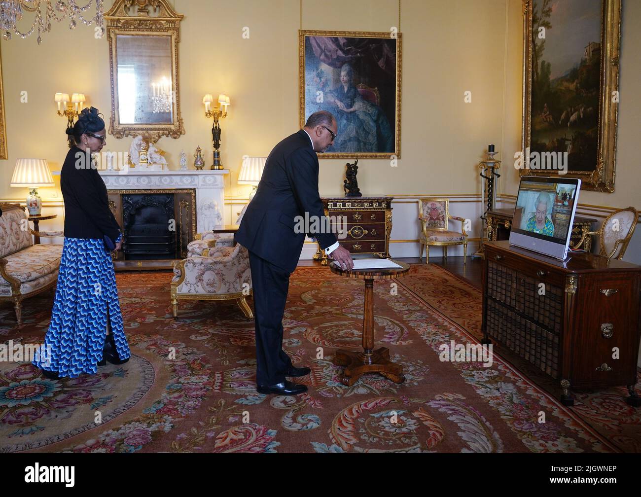 Königin Elizabeth II, die sich im Schloss Windsor aufhielt, erscheint auf einem Videolink während einer virtuellen Audienz, um Dr. Rajendra Singh, hohe Kommissarin für die Kooperative Republik Guyana, und seine Frau Shakuntala Singh im Buckingham Palace, London, zu empfangen. Bilddatum: Mittwoch, 13. Juli 2022. Stockfoto