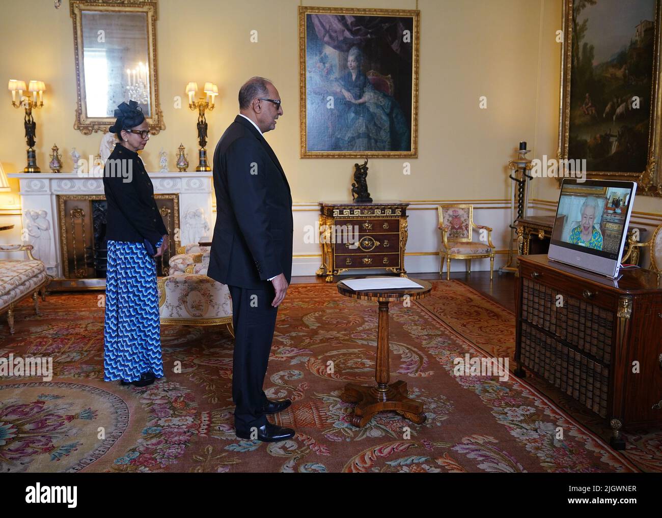 Königin Elizabeth II, die sich im Schloss Windsor aufhielt, erscheint auf einem Videolink während einer virtuellen Audienz, um Dr. Rajendra Singh, hohe Kommissarin für die Kooperative Republik Guyana, und seine Frau Shakuntala Singh im Buckingham Palace, London, zu empfangen. Bilddatum: Mittwoch, 13. Juli 2022. Stockfoto