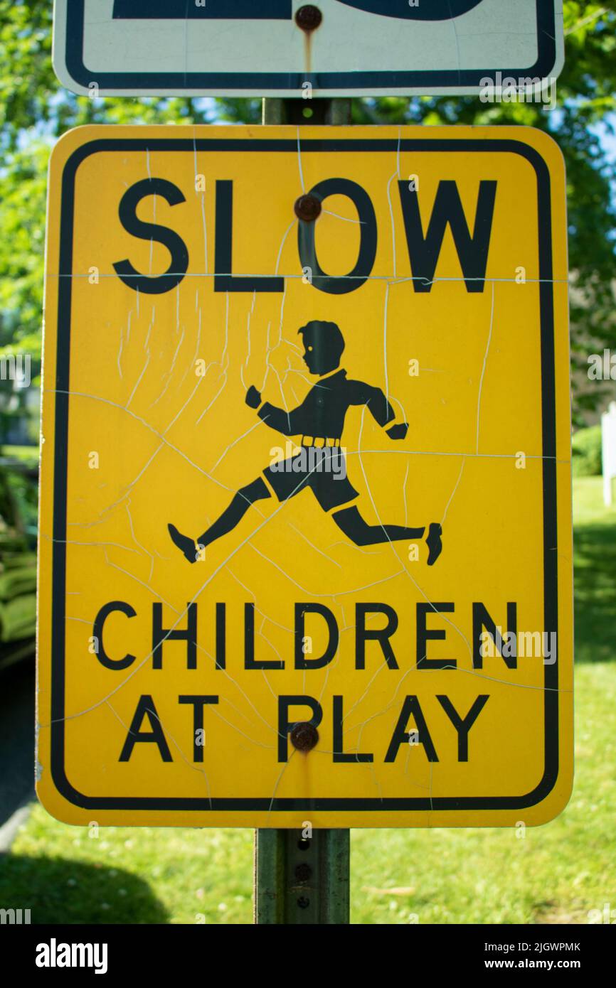 Nahaufnahme von Slow Children at Play, schwarzes und orangefarbenes Schild am Straßenrand Stockfoto