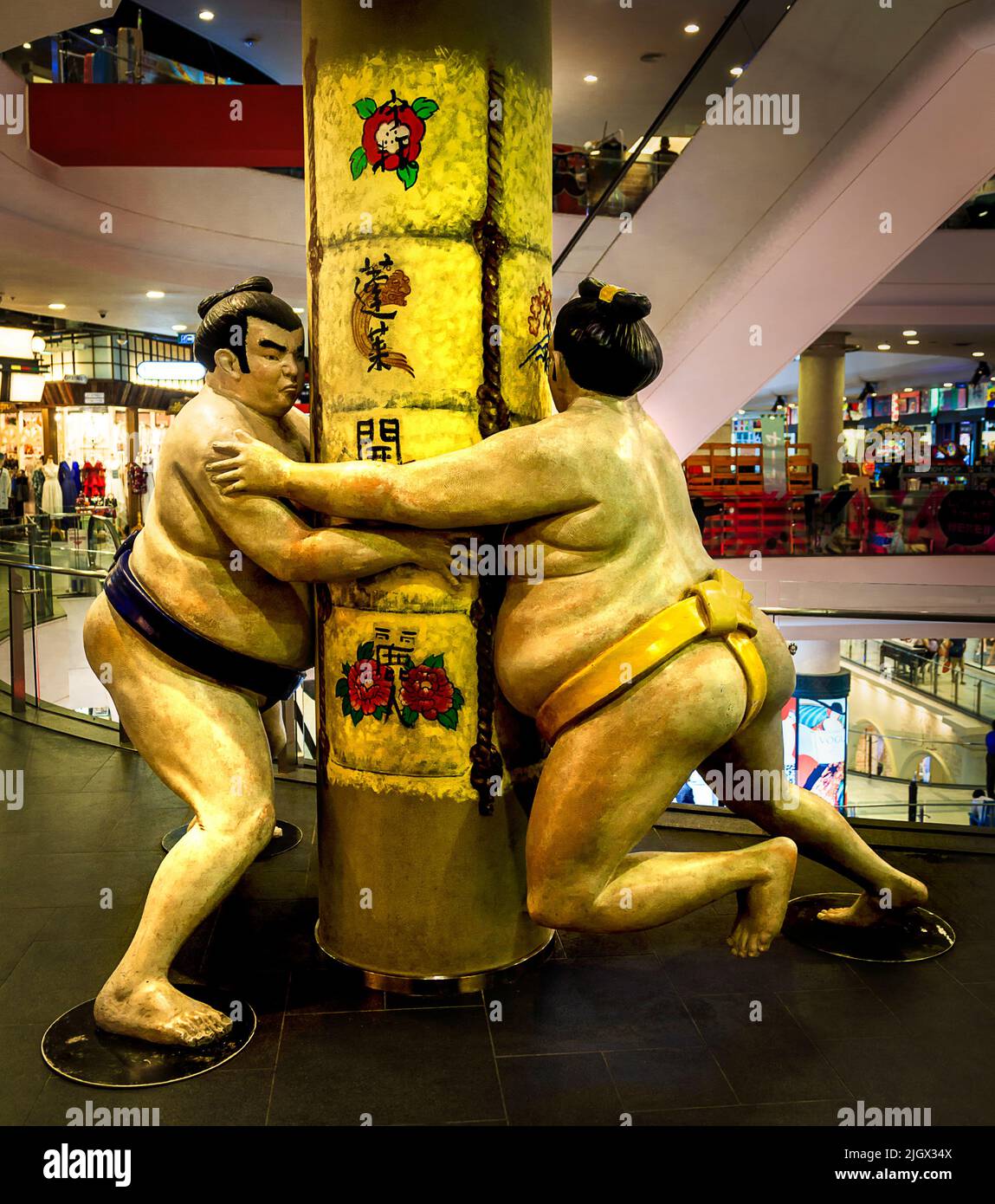 Sumo-Ringer-Statuen kämpfen sich um einen Stützbalken im Terminal 21 in Bangkok. Stockfoto