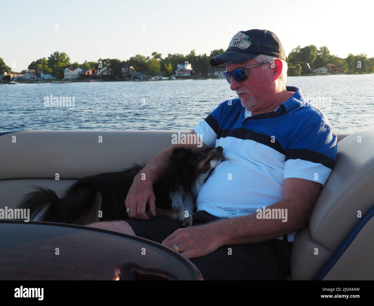 MANN MIT HUND AUF DEM BOOT Stockfoto