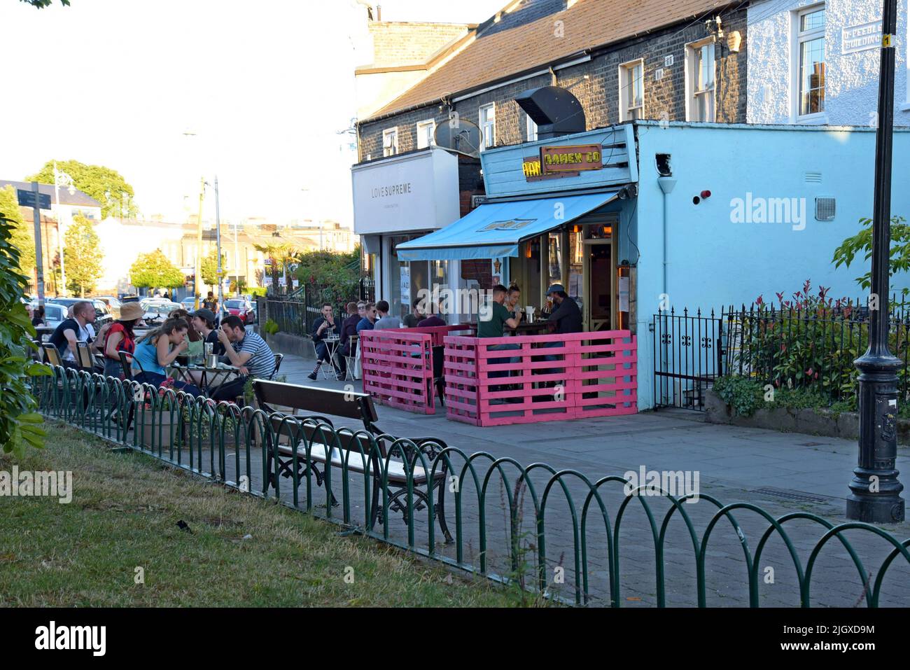 Menschen, die draußen auf dem Bürgersteig im trendigen Innenstadtviertel von Stoneybatter, Dublin, Irland, essen, Juli 2022 Stockfoto