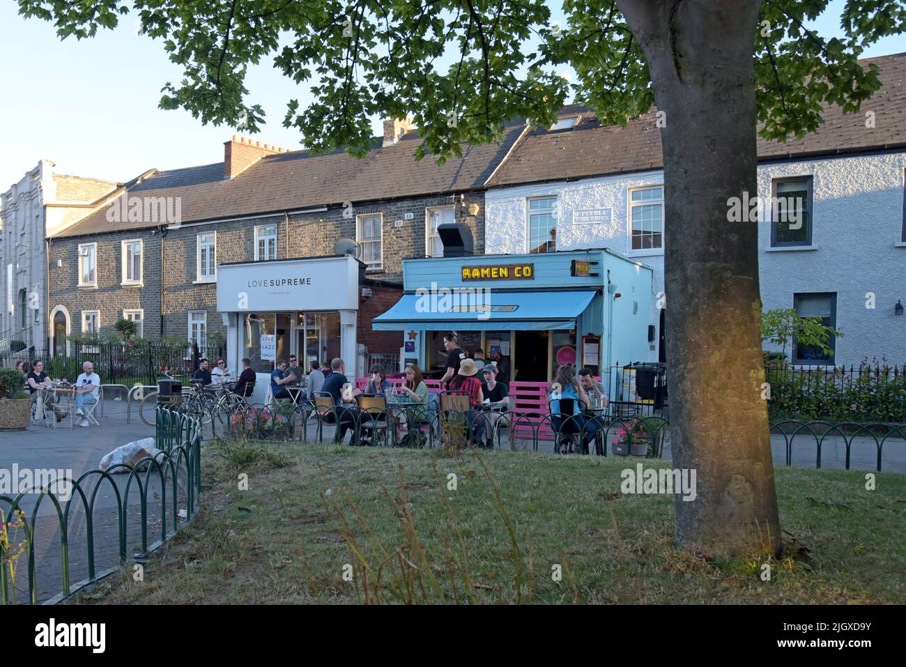 Menschen, die draußen auf dem Bürgersteig im trendigen Innenstadtviertel von Stoneybatter, Dublin, Irland, essen, Juli 2022 Stockfoto