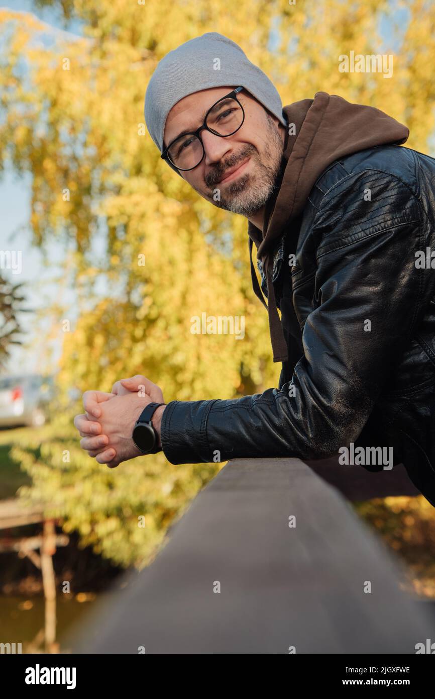 Schöner lächelnder Mann im Jackenkittel im Herbst Stockfoto