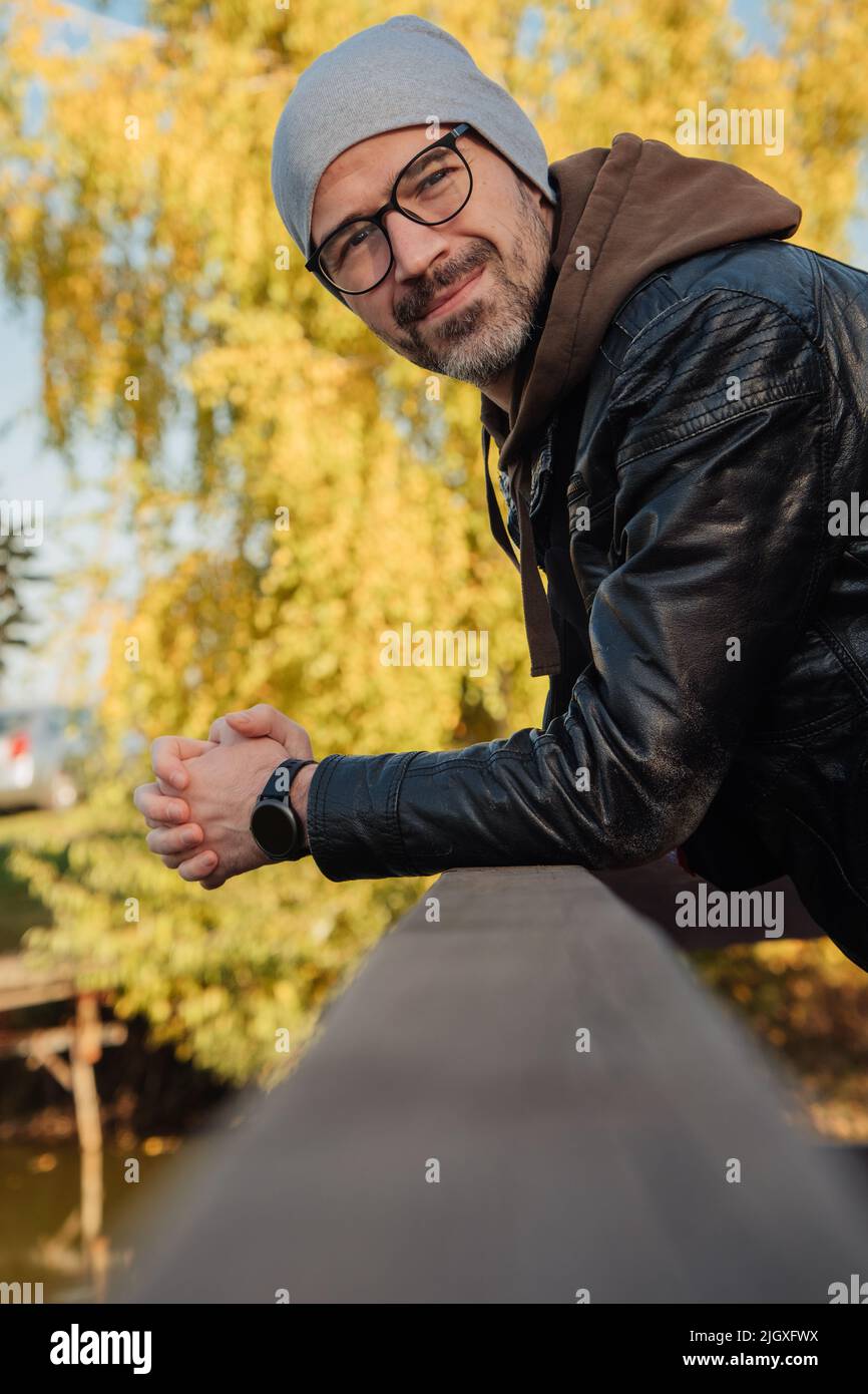 Schöner lächelnder Mann im Jackenkittel im Herbst Stockfoto