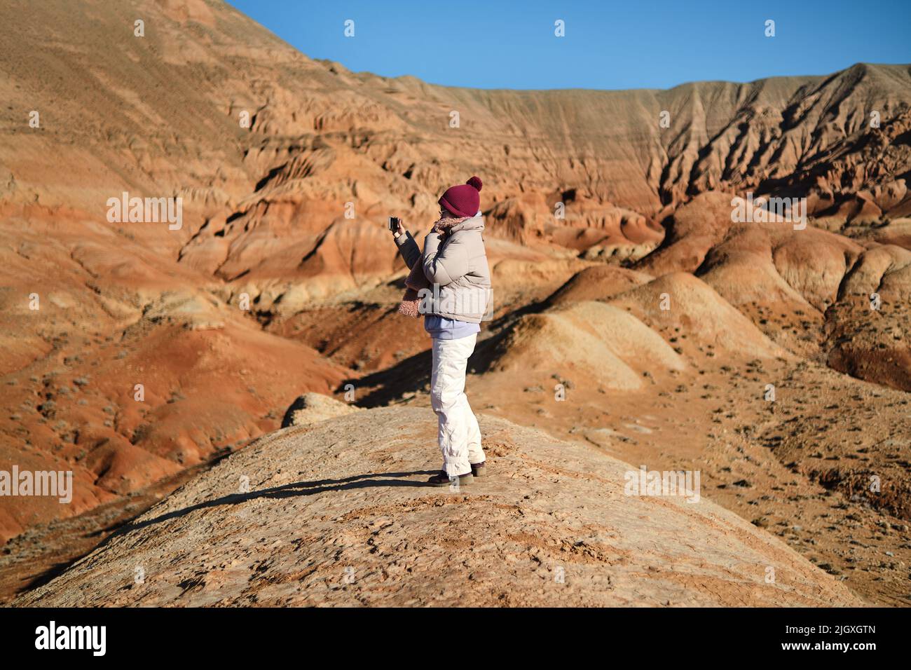 Asiatische Frau, die telefoniert und Selfie gemacht hat Rote Berge von Boguty Stockfoto
